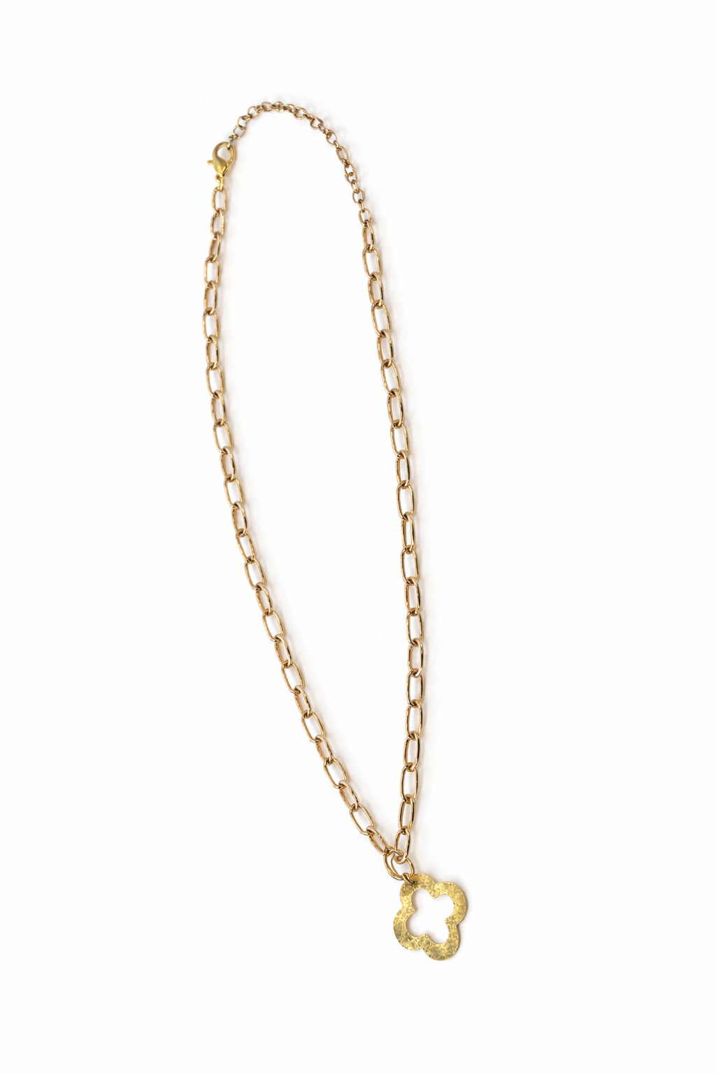 Gold chain necklace with a clover-shaped pendant on a white background