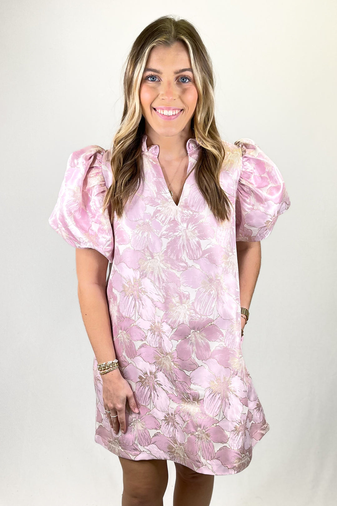 Woman wearing a pink floral dress against a white background