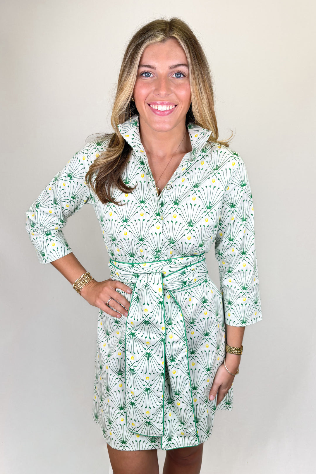 Woman wearing green and white patterned collared dress with tie waist and three quarter sleeves | Walker Boutique