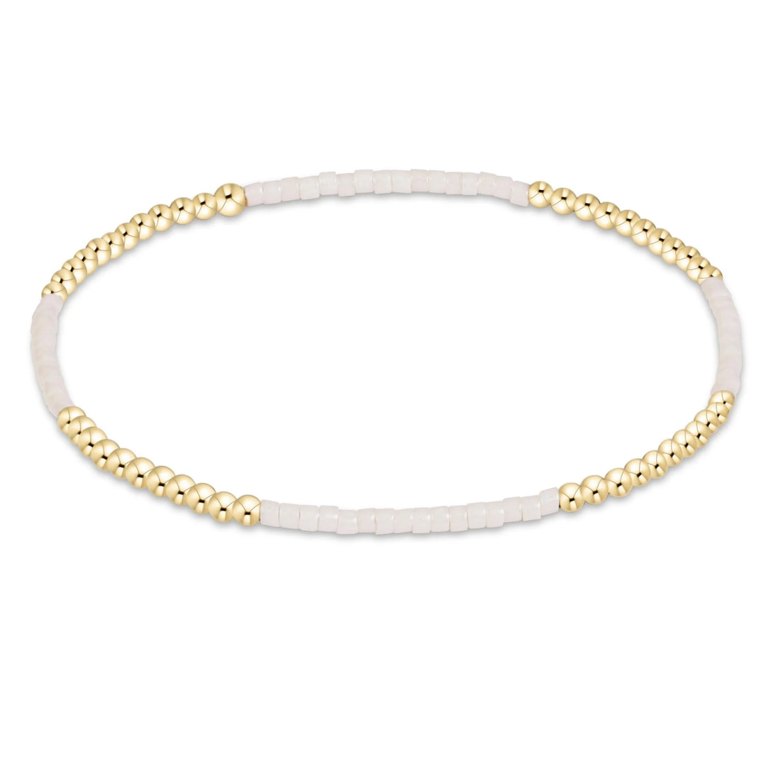 CREAM AND GOLD BEADED BRACELET ON WHITE BACKGROUND