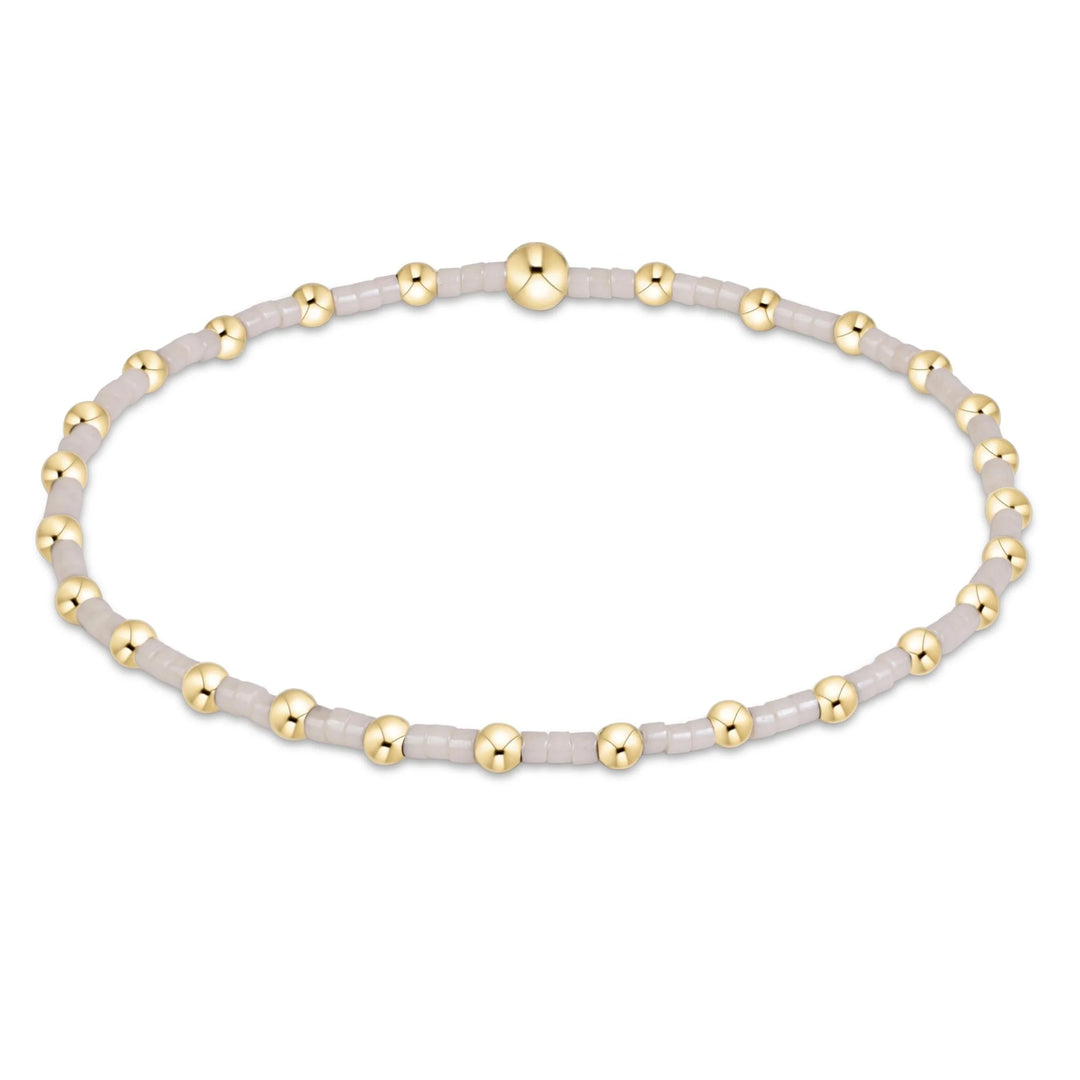 CREAM AND GOLD BEADED BRACELET ON WHITE BACKGROUND