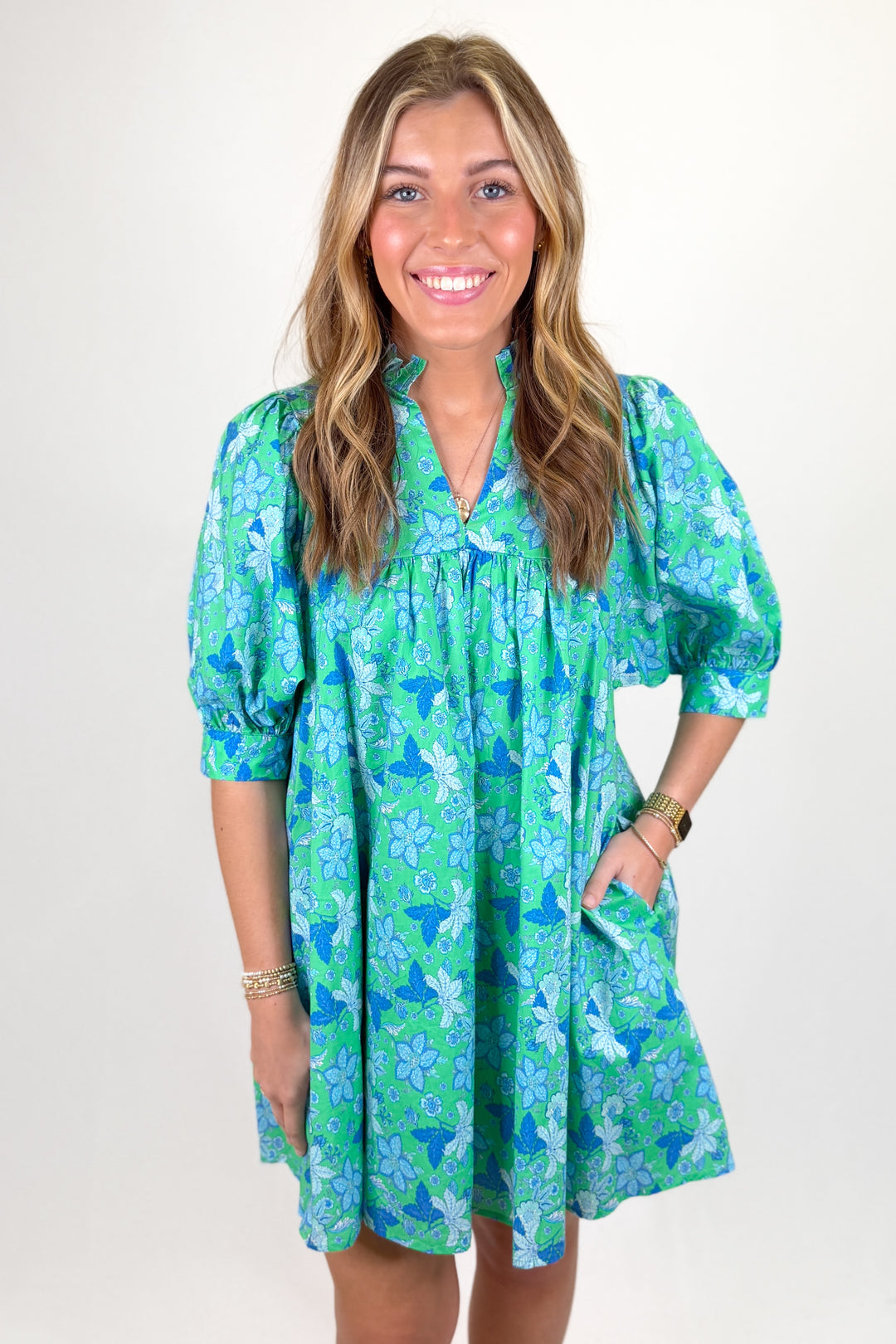 Woman wearing a blue and green floral dress.