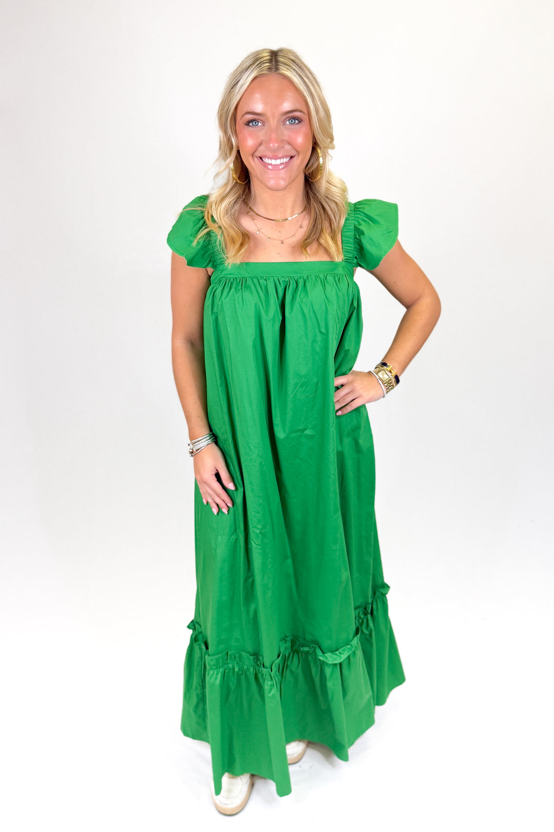 Woman wearing a green ruffle sleeve midi dress.