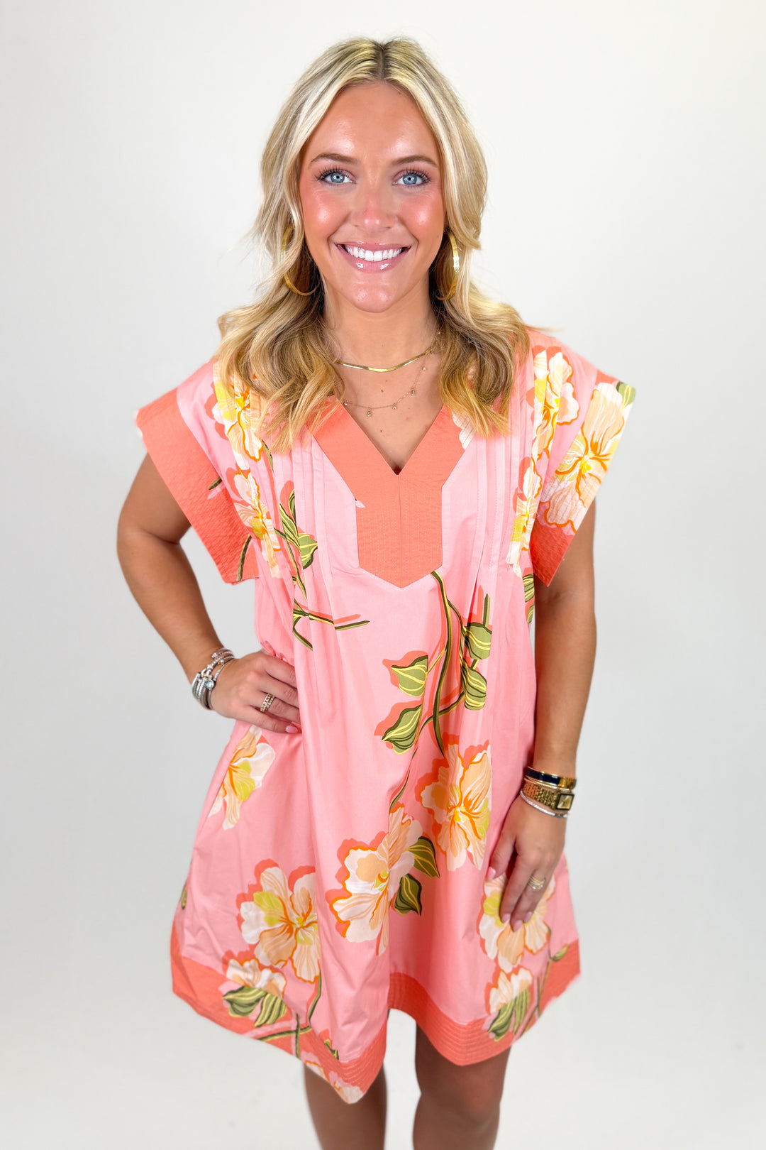 Woman wearing a coral floral mini dress.