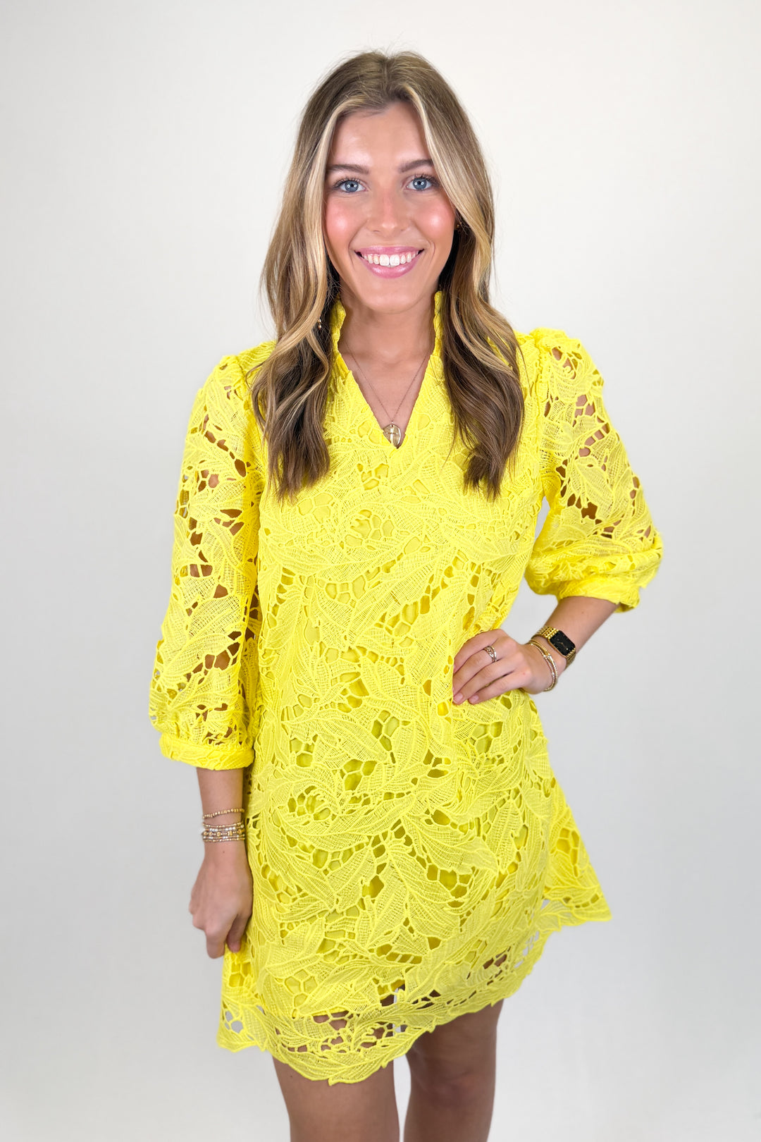 Woman wearing a yellow lace dress.