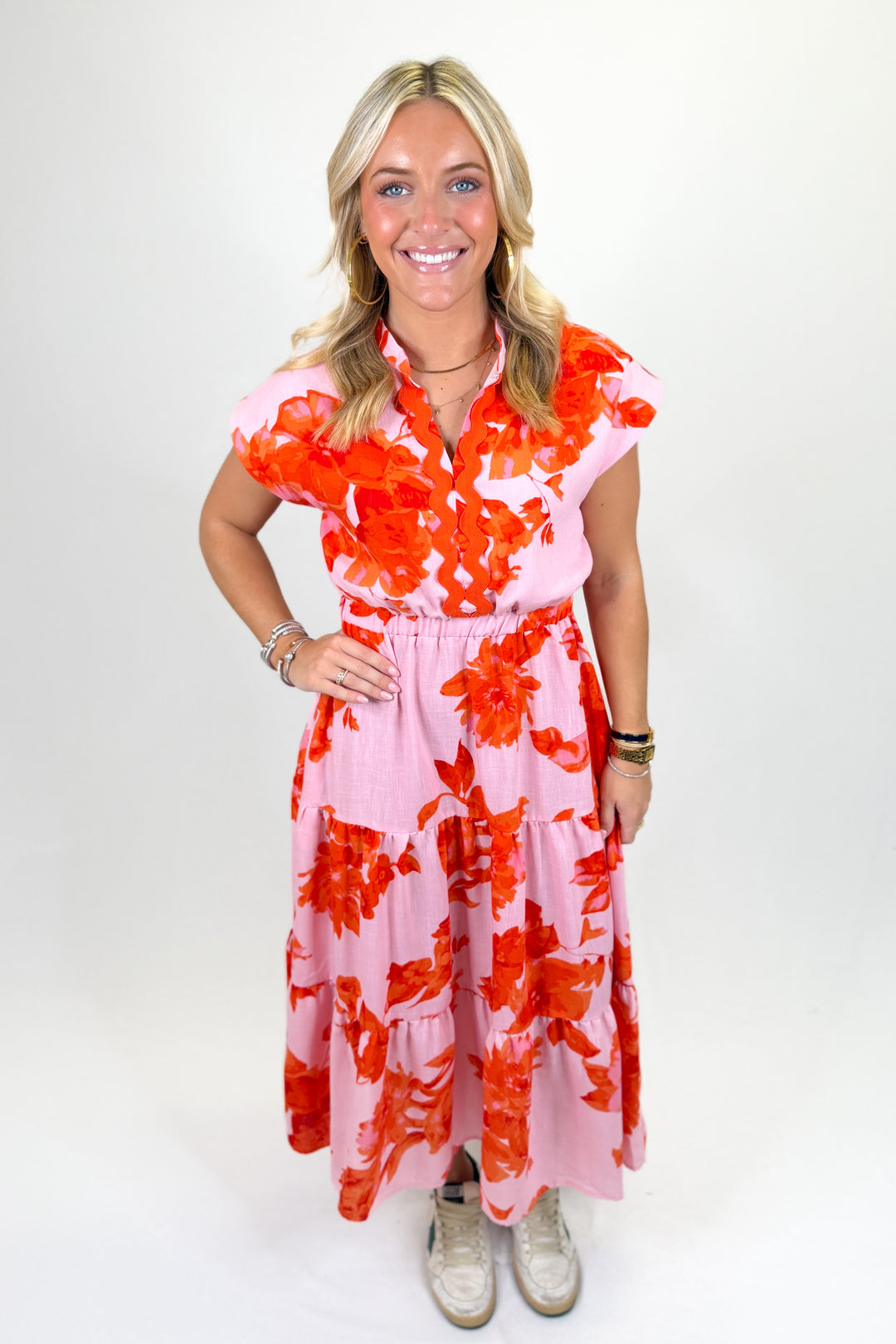 Woman wearing an orange and pink floral midi dress.