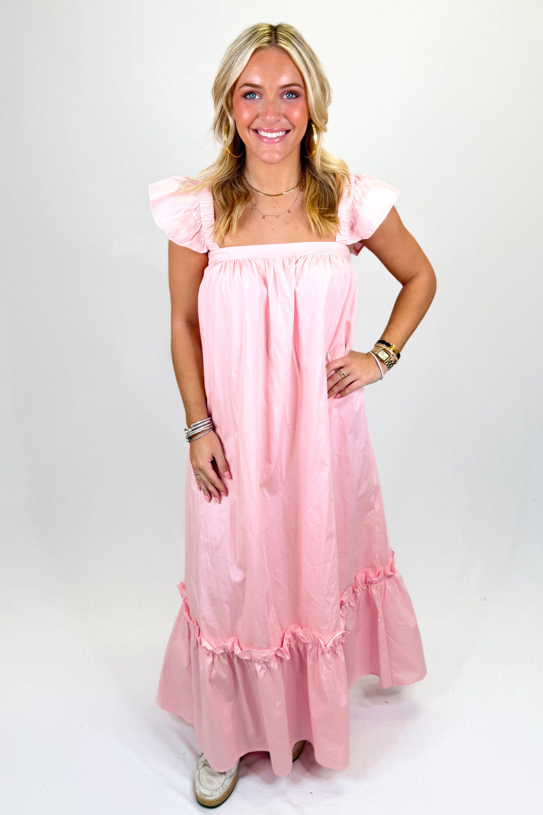 Woman wearing a baby pink midi dress.