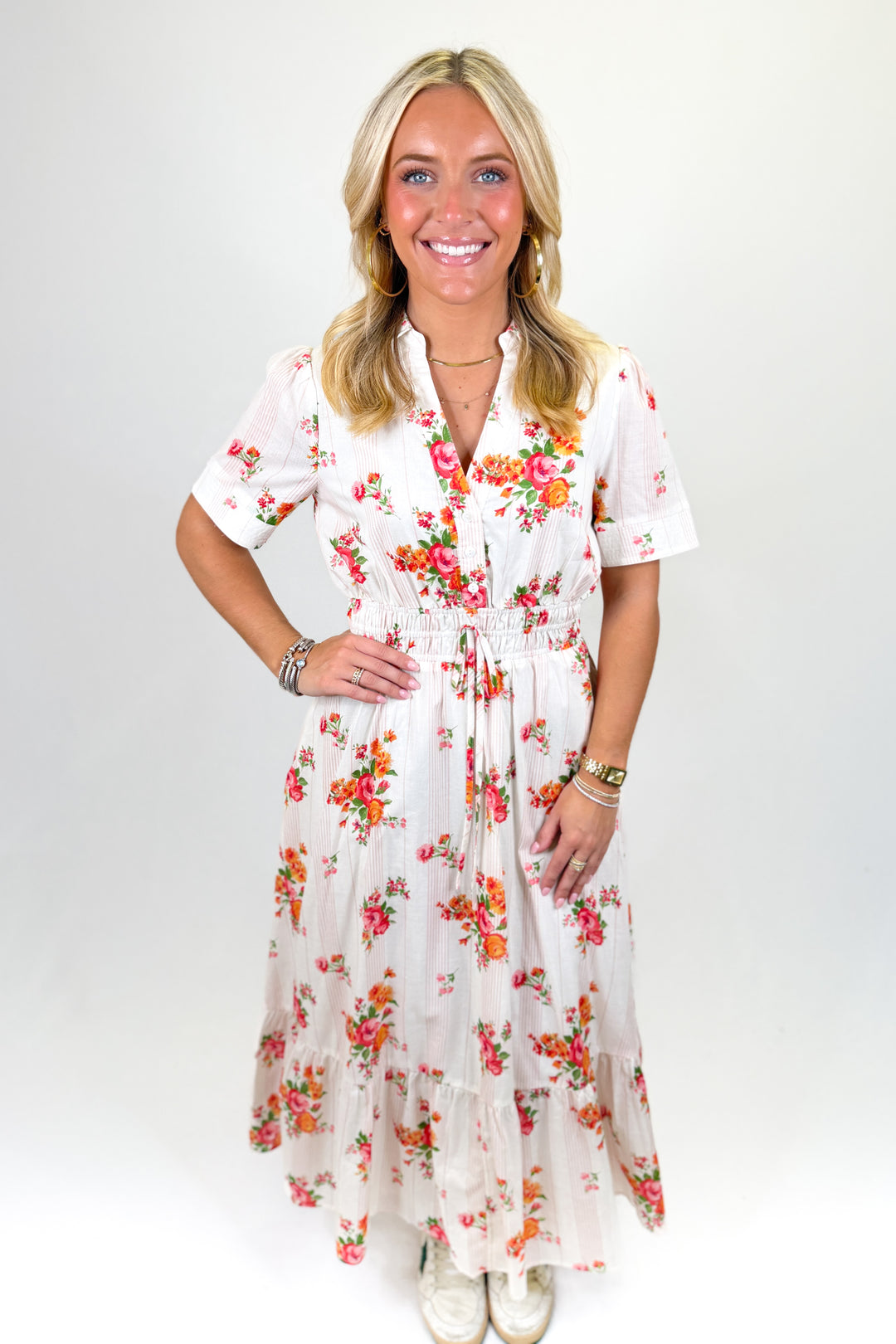 woman wearing a cream floral midi dress.