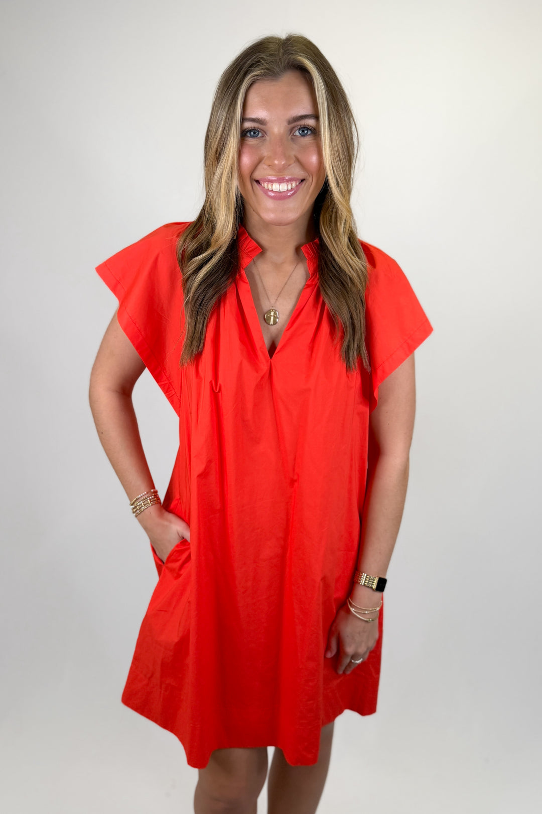 Woman wearing a coral v-neck short dress.