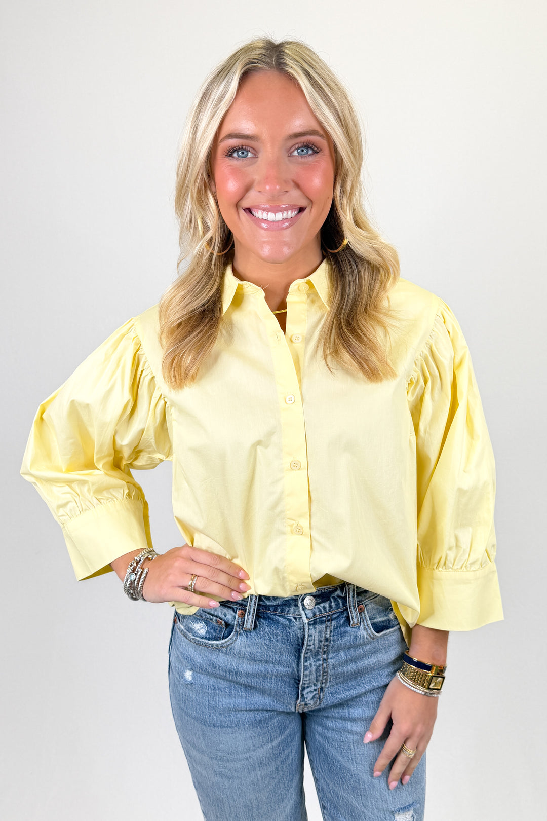 Yellow button-front blouse with puff sleeves, classic collar, and relaxed fit paired with denim