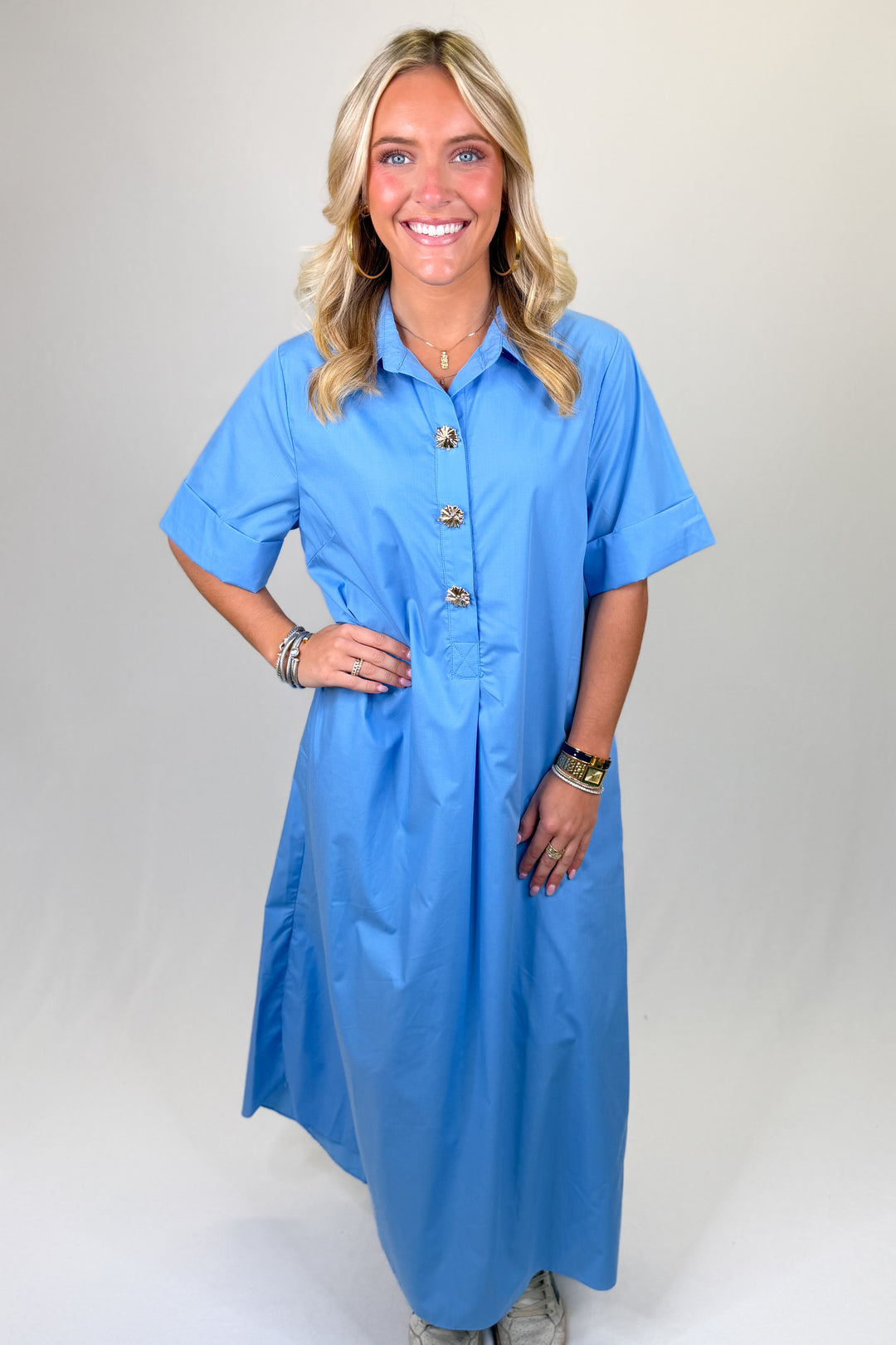 Blue women’s midi dress with short sleeves, collared neckline, and decorative statement buttons