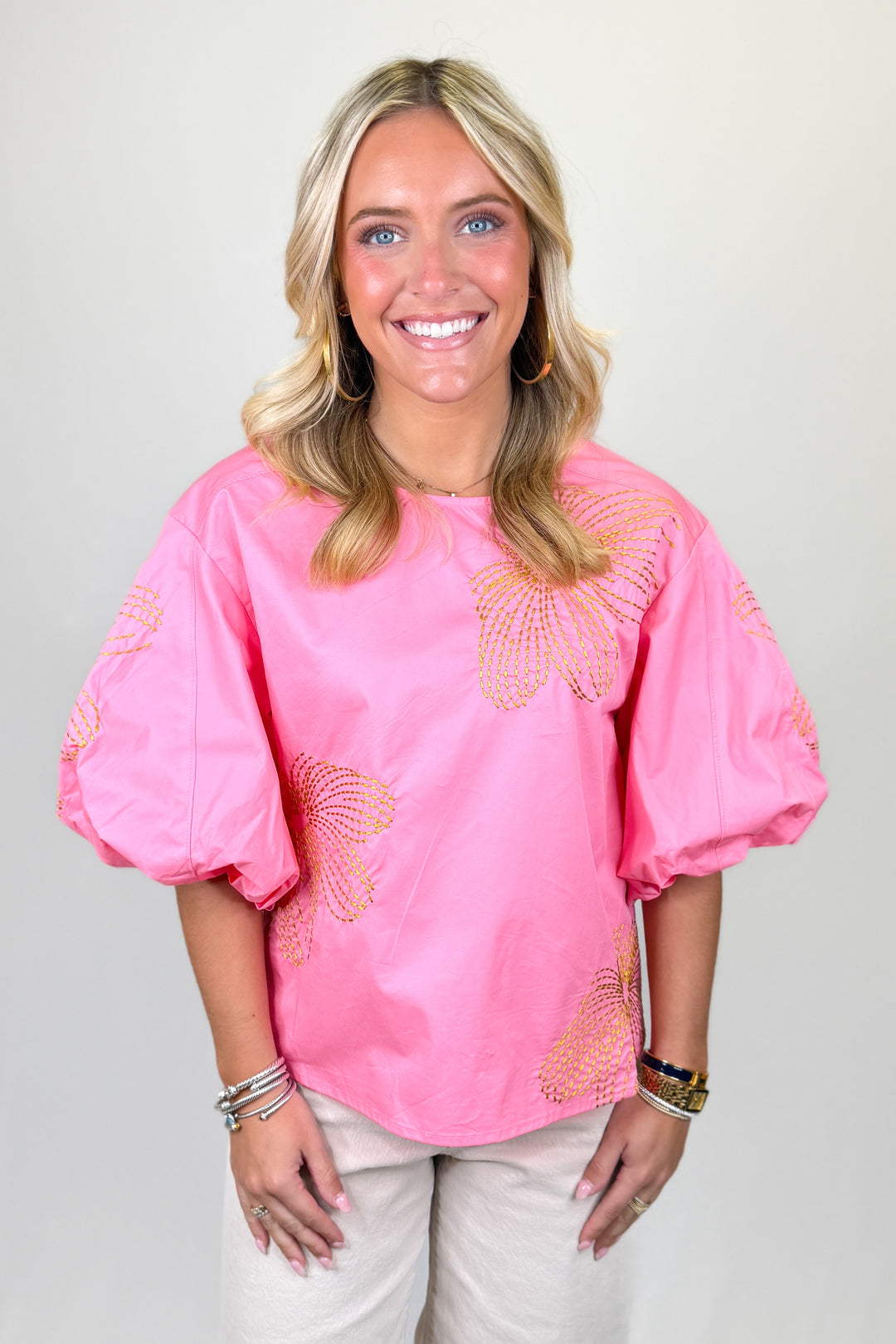 Bright pink women’s blouse with gold embroidered floral details and puff sleeves