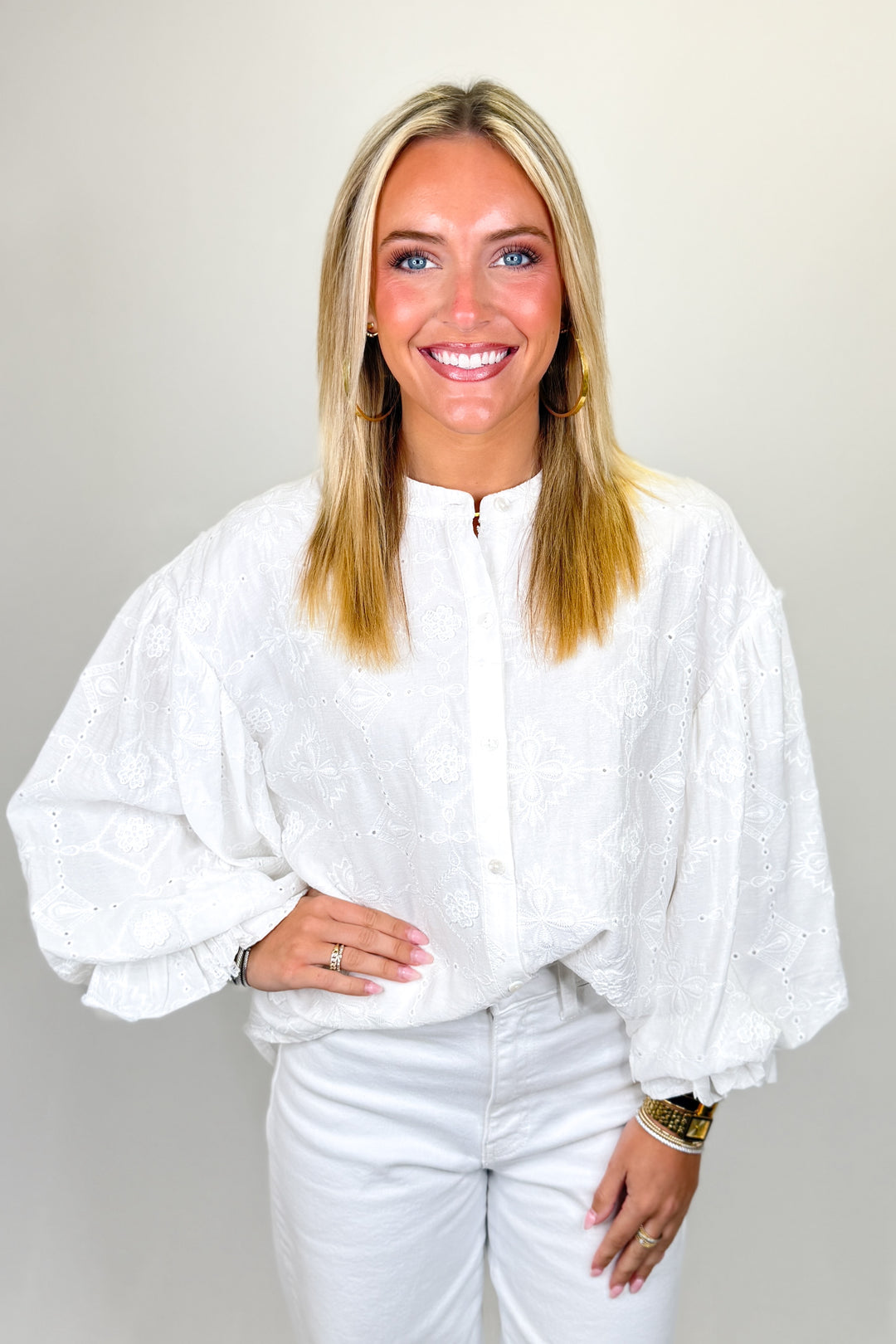 Boutique women’s white embroidered eyelet blouse with long sleeves, button front, and lightweight fabric