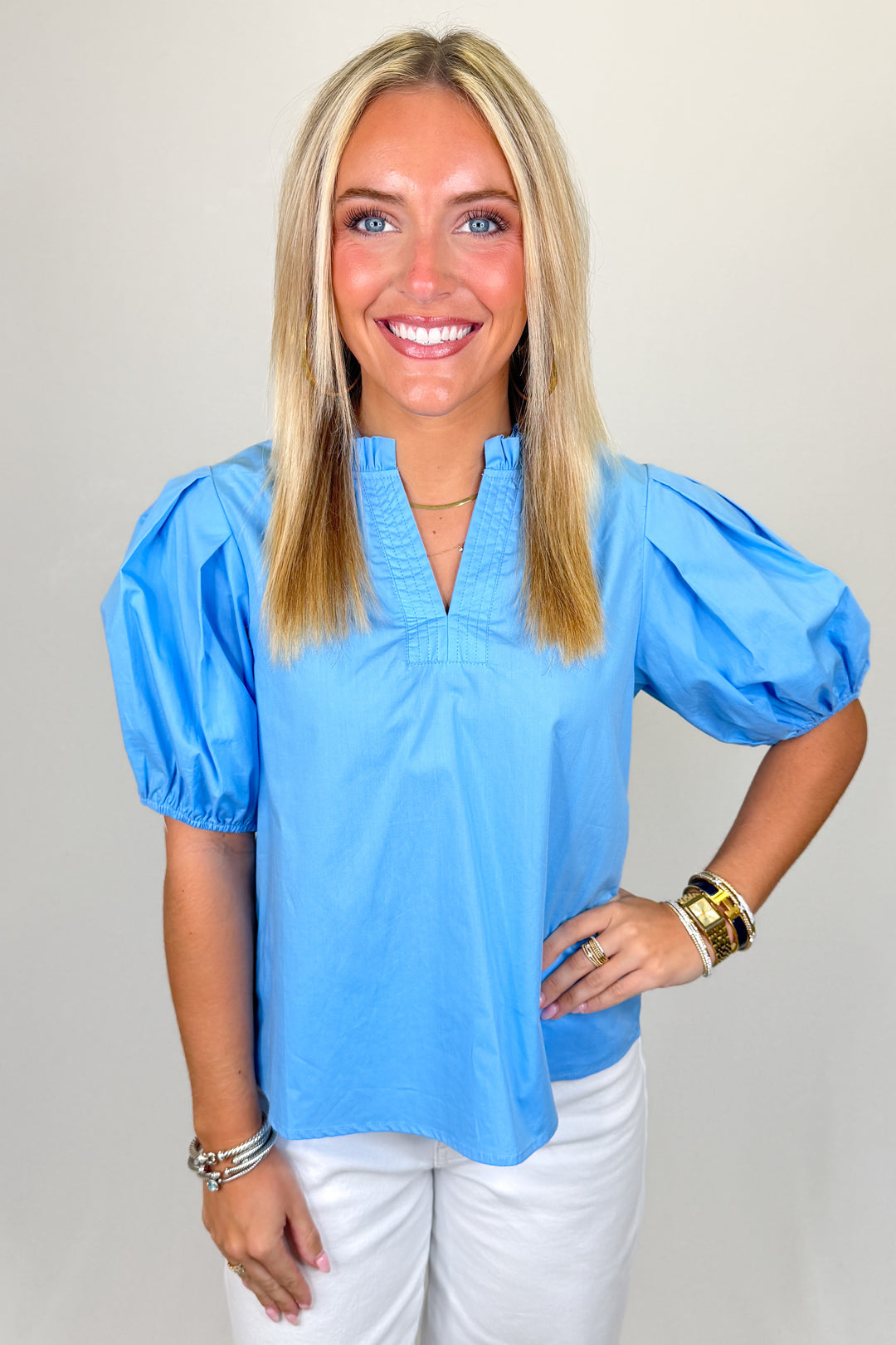 Boutique women’s blue puff sleeve blouse with ruffle neckline and lightweight fabric, casual spring top