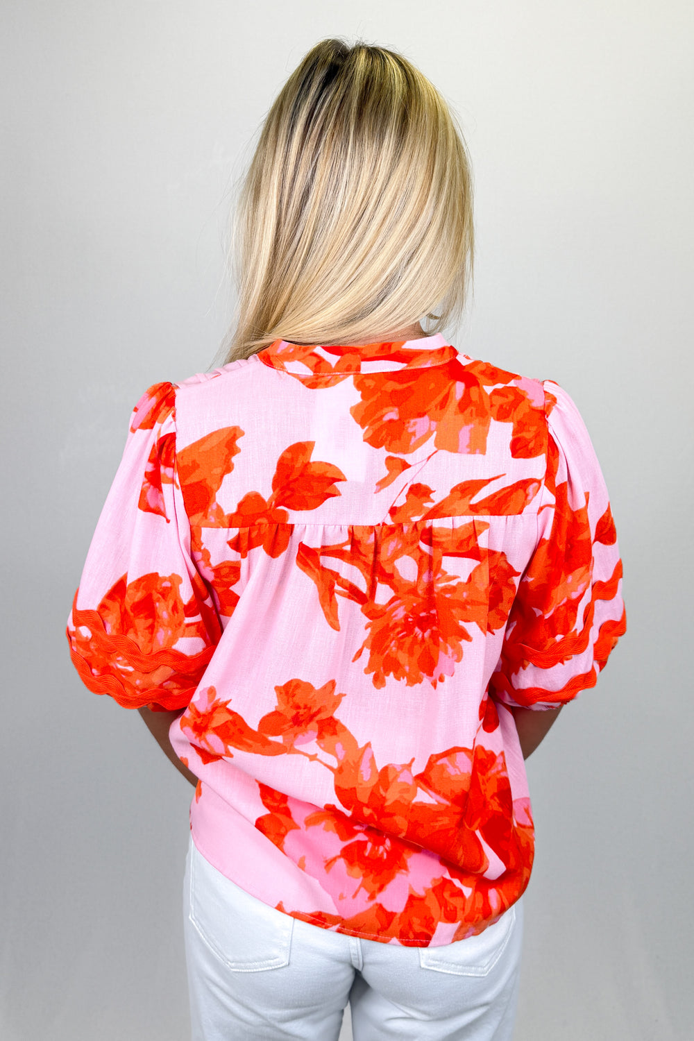 Boutique women’s pink and red floral print blouse with puff sleeves, lightweight fabric, and relaxed fit