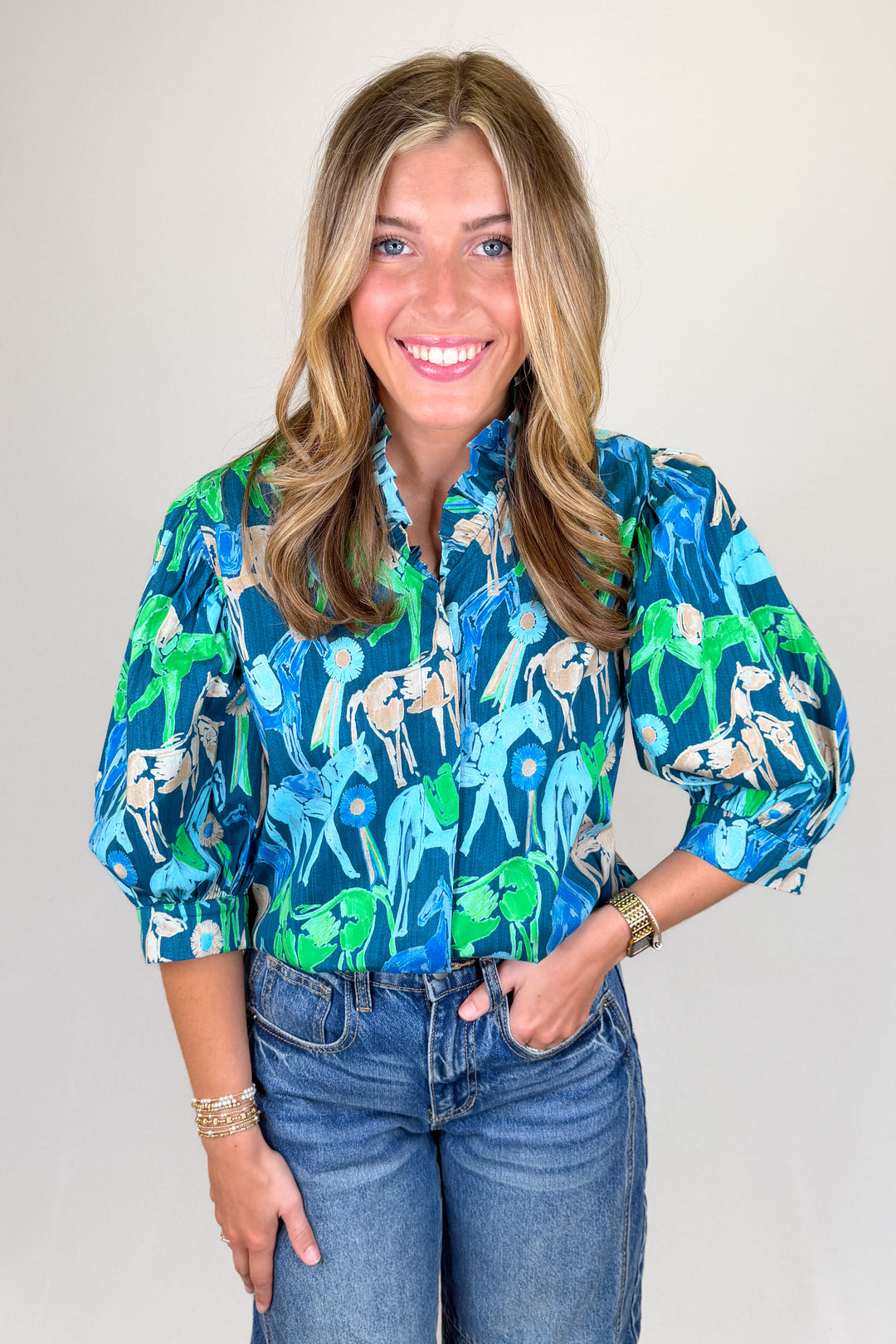 Blue and green horse print blouse with puff sleeves and ruffle collar styled with denim jeans | Walker Boutique