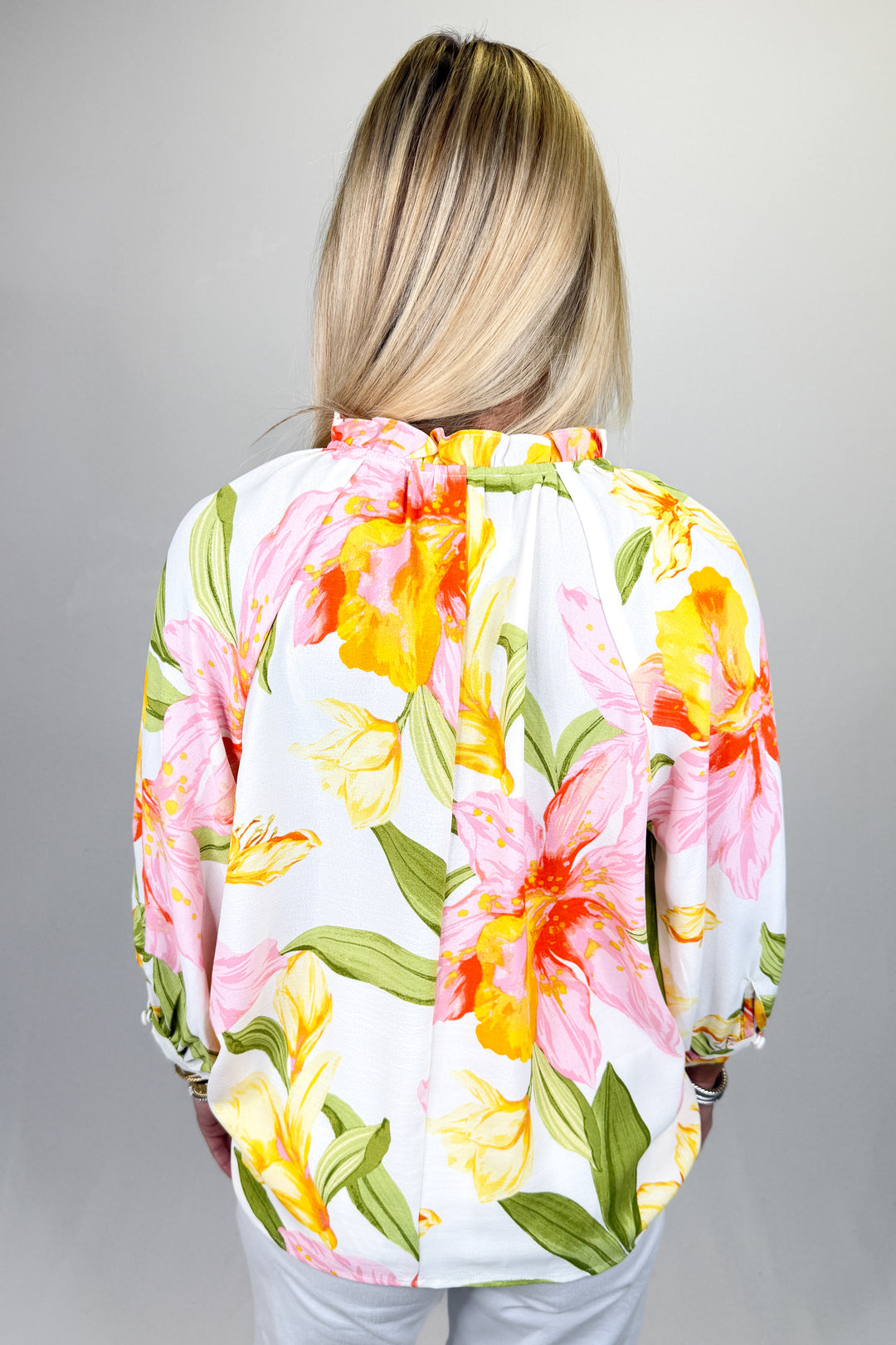 Boutique women’s floral print blouse in white with pink and yellow flowers, tie neck detail, and lightweight fabric