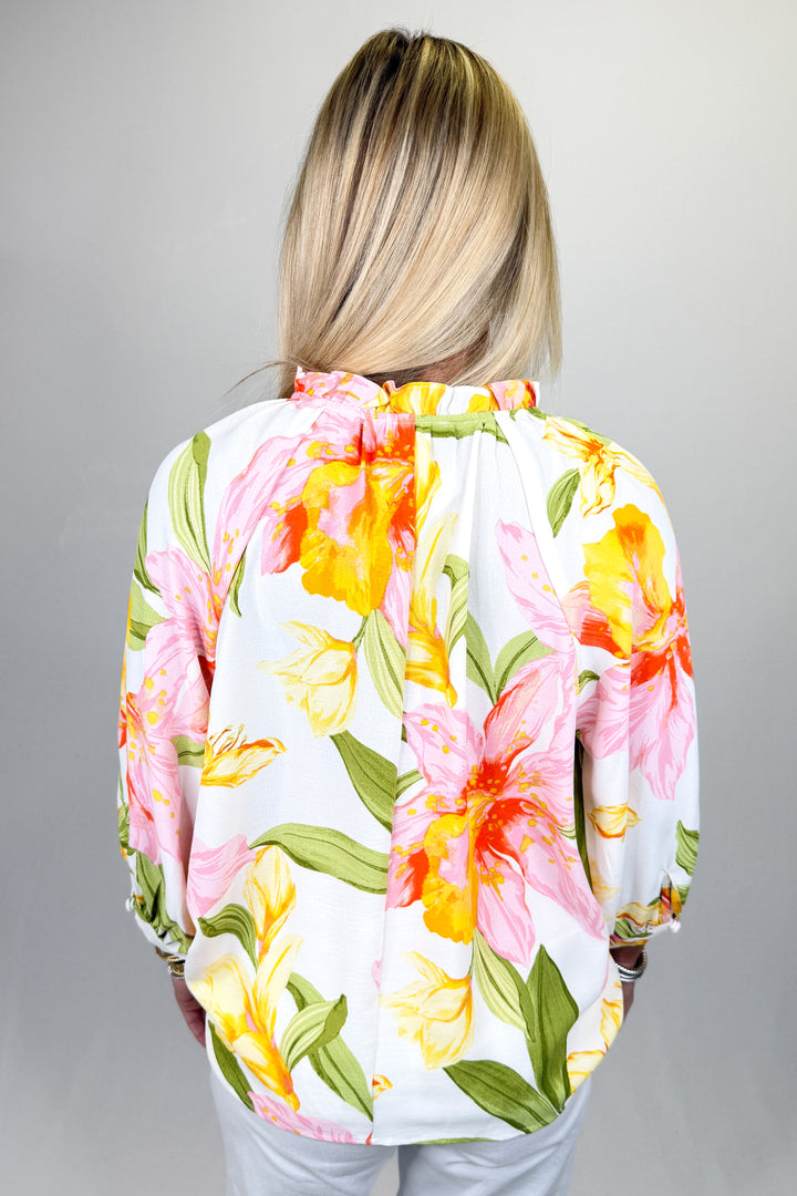 Boutique women’s floral print blouse in white with pink and yellow flowers, tie neck detail, and lightweight fabric