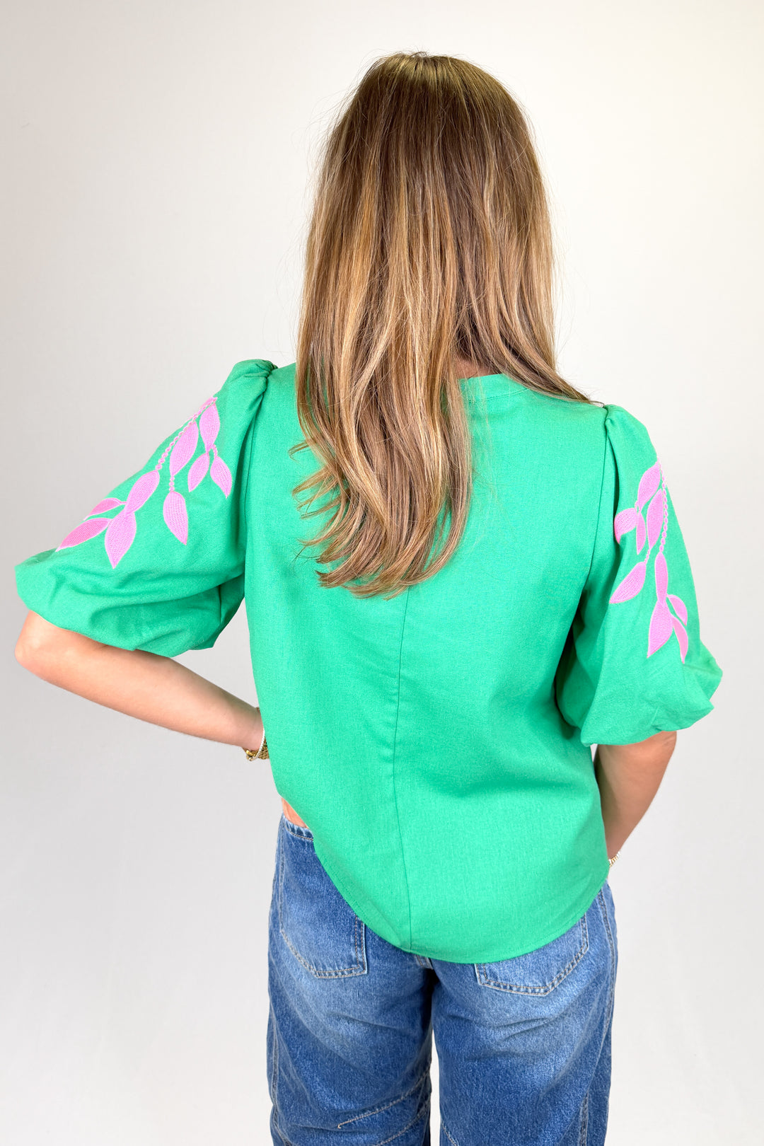 Boutique women’s green embroidered blouse with pink leaf detailing, puff sleeves, and lightweight fabric