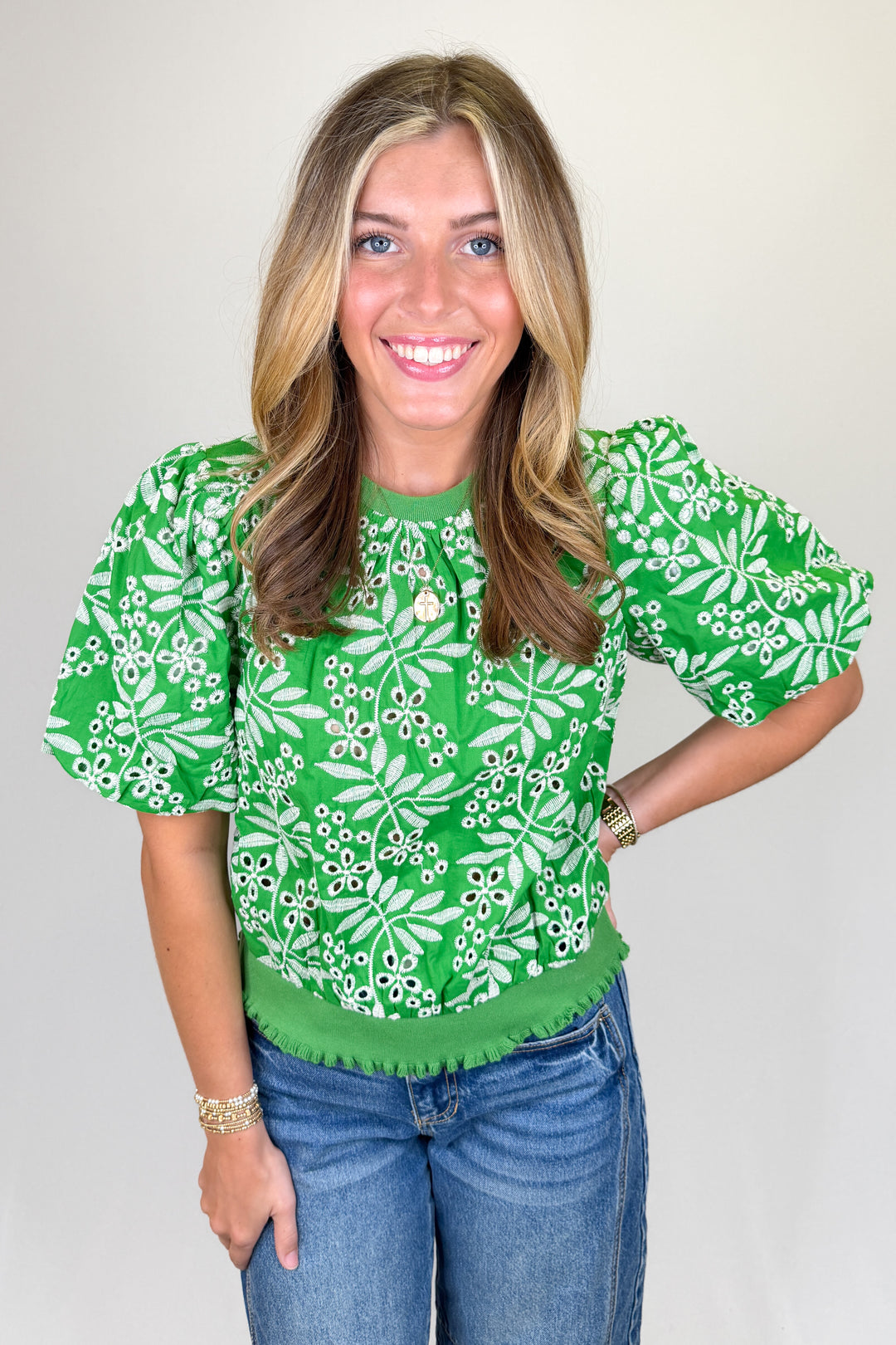Boutique women’s green embroidered top with white floral pattern, puff sleeves, and textured detailing