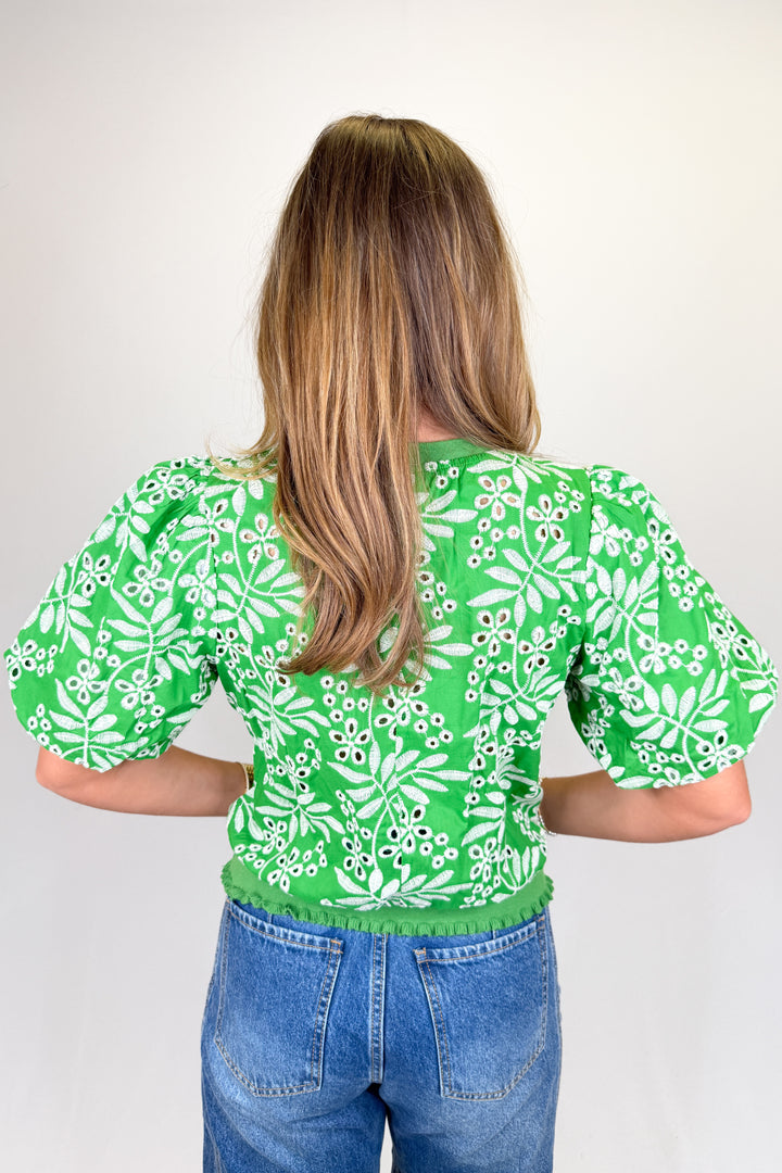 Boutique women’s green embroidered top with white floral pattern, puff sleeves, and textured detailing