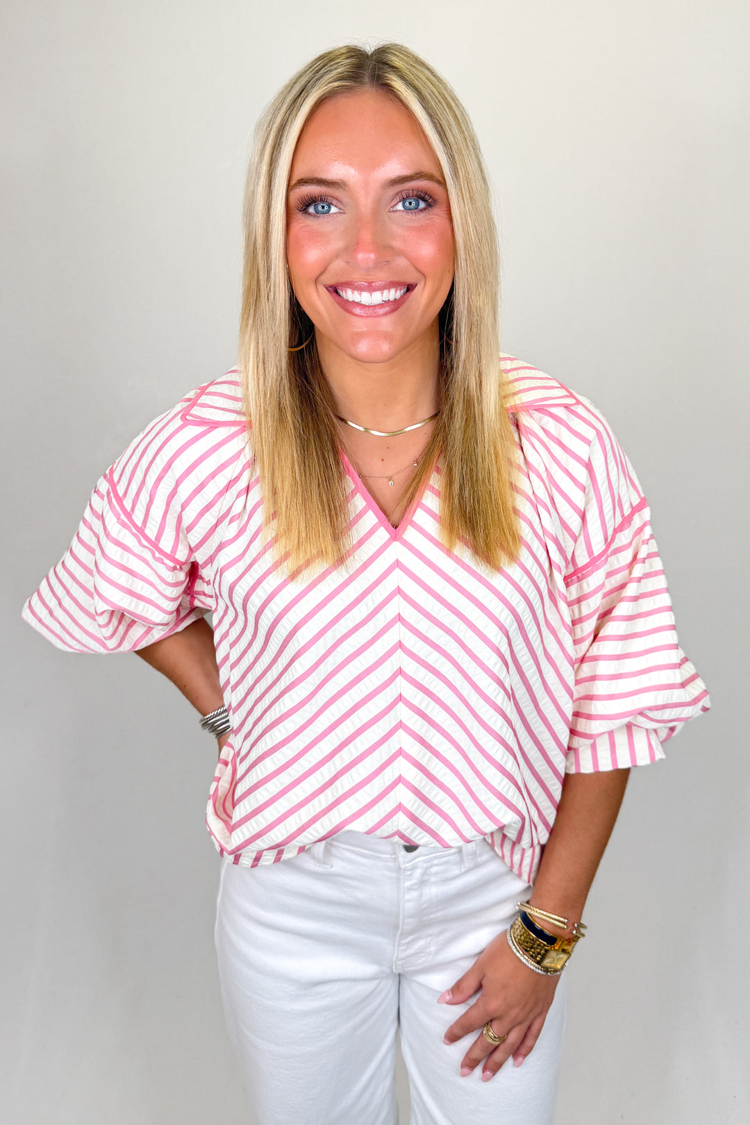 Boutique women’s pink and white striped top with v-neckline, relaxed fit, and lightweight fabric