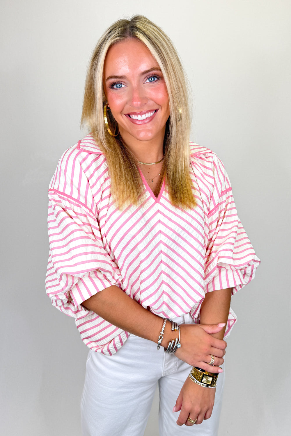 Boutique women’s pink and white striped top with v-neckline, relaxed fit, and lightweight fabric