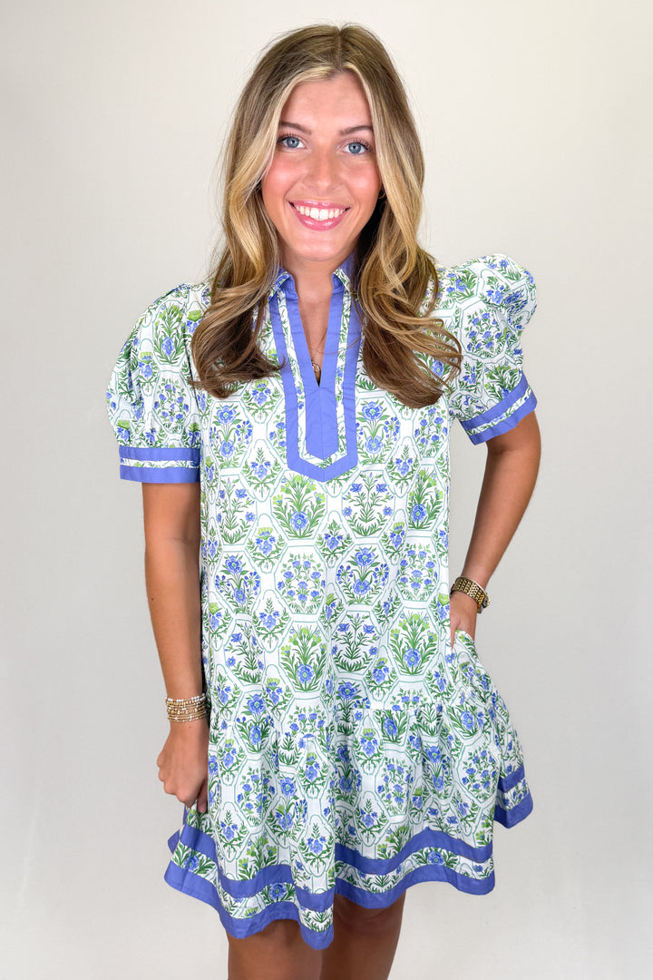 Boutique women’s floral print dress in white, blue, and green with contrast neckline, short sleeves, and flowy fit