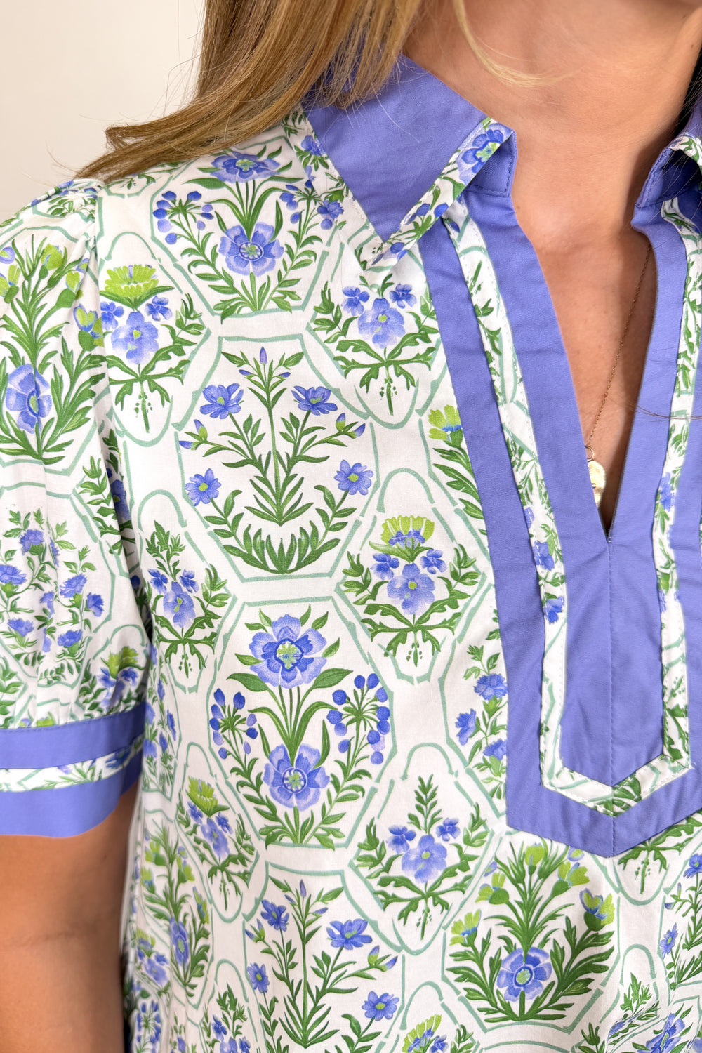 Boutique women’s floral print dress in white, blue, and green with contrast neckline, short sleeves, and flowy fit