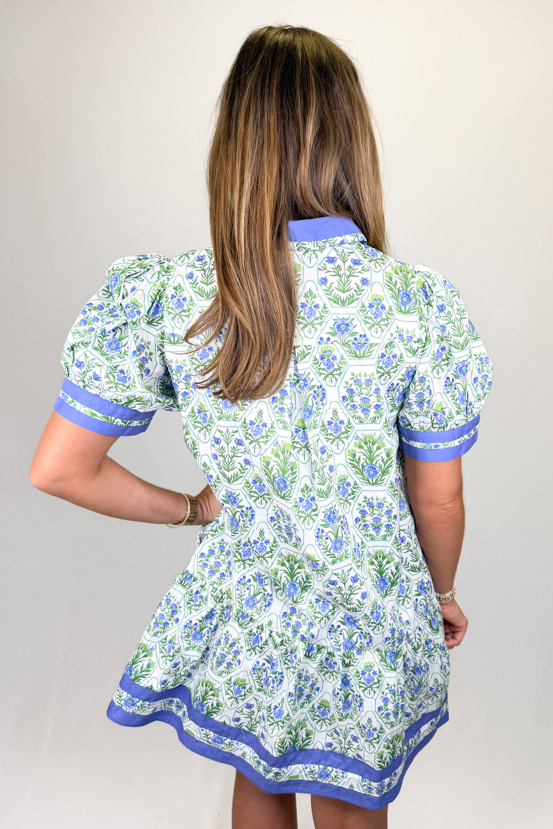Boutique women’s floral print dress in white, blue, and green with contrast neckline, short sleeves, and flowy fit