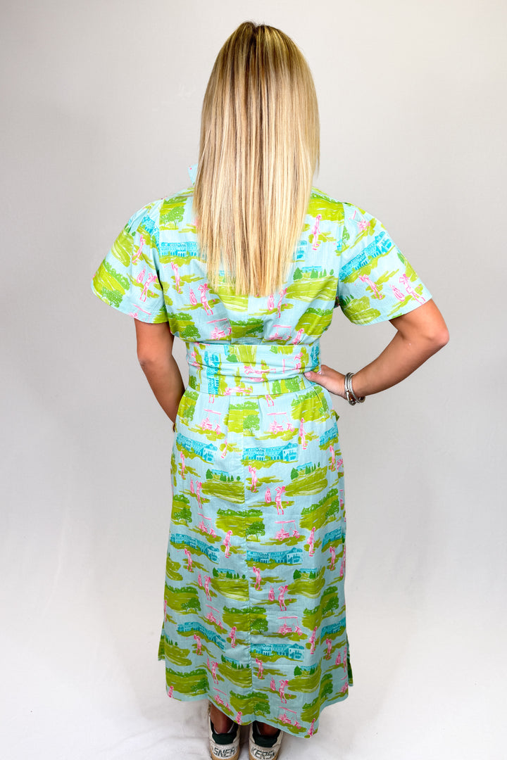 Women’s green and blue printed midi dress with collar neckline, short sleeves, and bamboo buckle belt, styled with sneakers