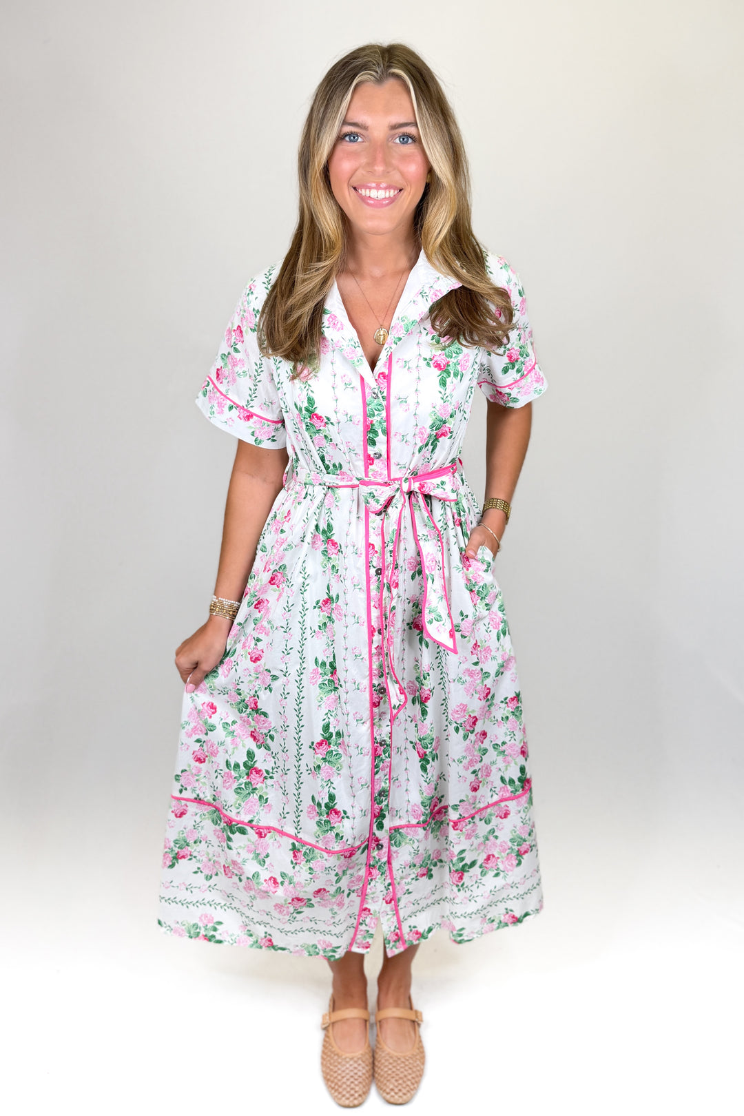 Women’s white and pink floral dress with button front, short sleeves and adjustable waist tie