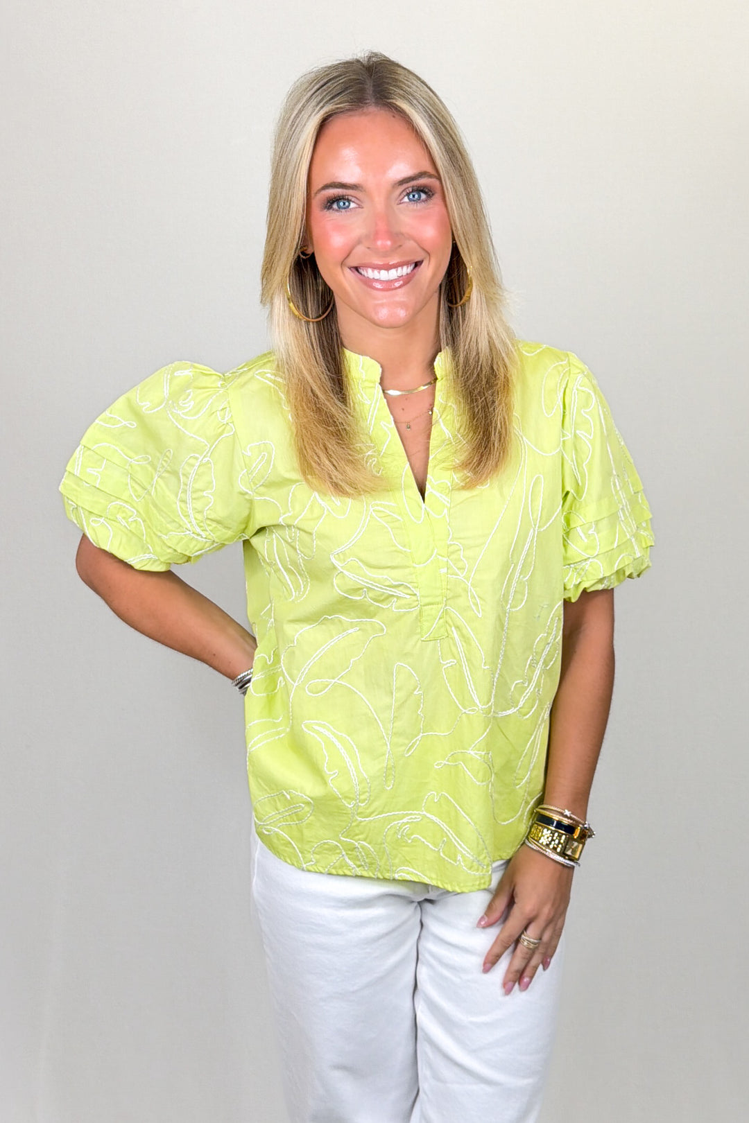 Light green textured top with puff sleeves, split neckline, and subtle tonal embroidery, featuring a relaxed fit and lightweight feel