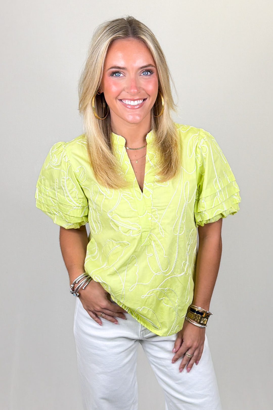 Light green textured top with puff sleeves, split neckline, and subtle tonal embroidery, featuring a relaxed fit and lightweight feel
