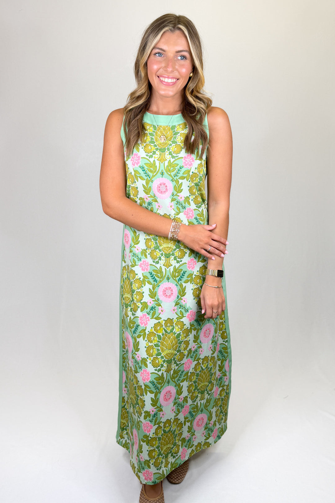 Green and pink floral print maxi dress with sleeveless design, high neckline, and straight silhouette, featuring a lightweight feel and classic fit