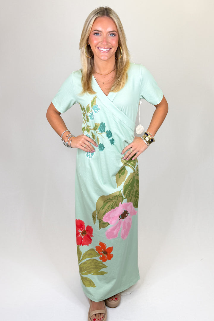 Mint green floral print maxi dress with short sleeves, wrap-style bodice, V-neckline, and straight skirt, featuring a lightweight feel and relaxed fit