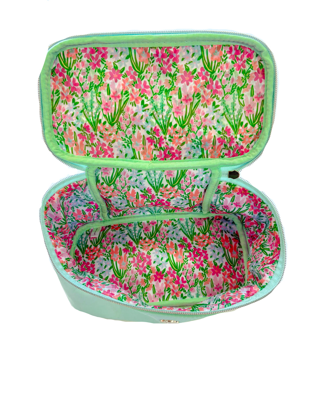 Inside view of mint cosmetic bag with bright floral lining and divided interior compartment.