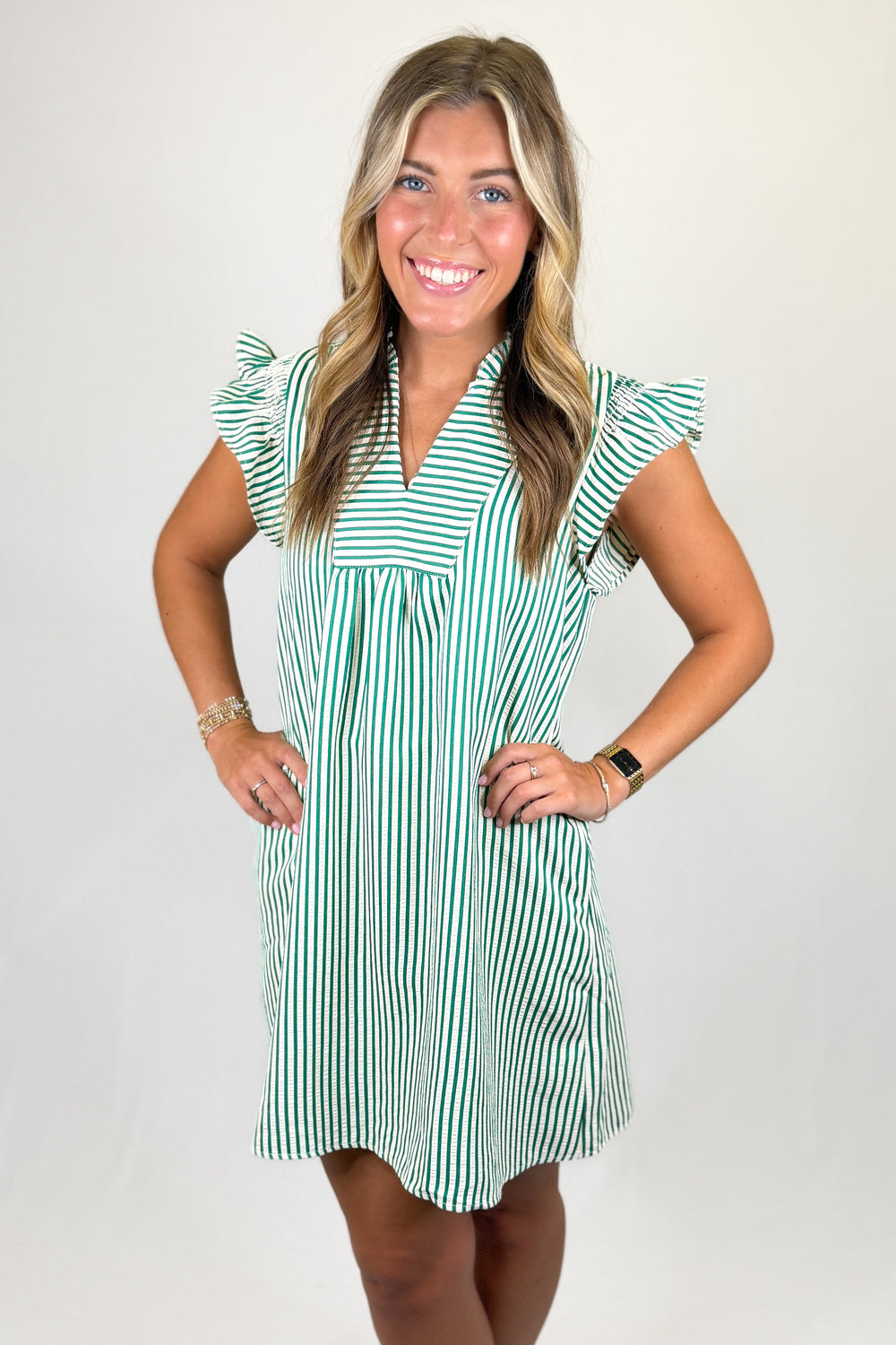 Green and white striped babydoll dress with ruffle sleeves and v-neckline