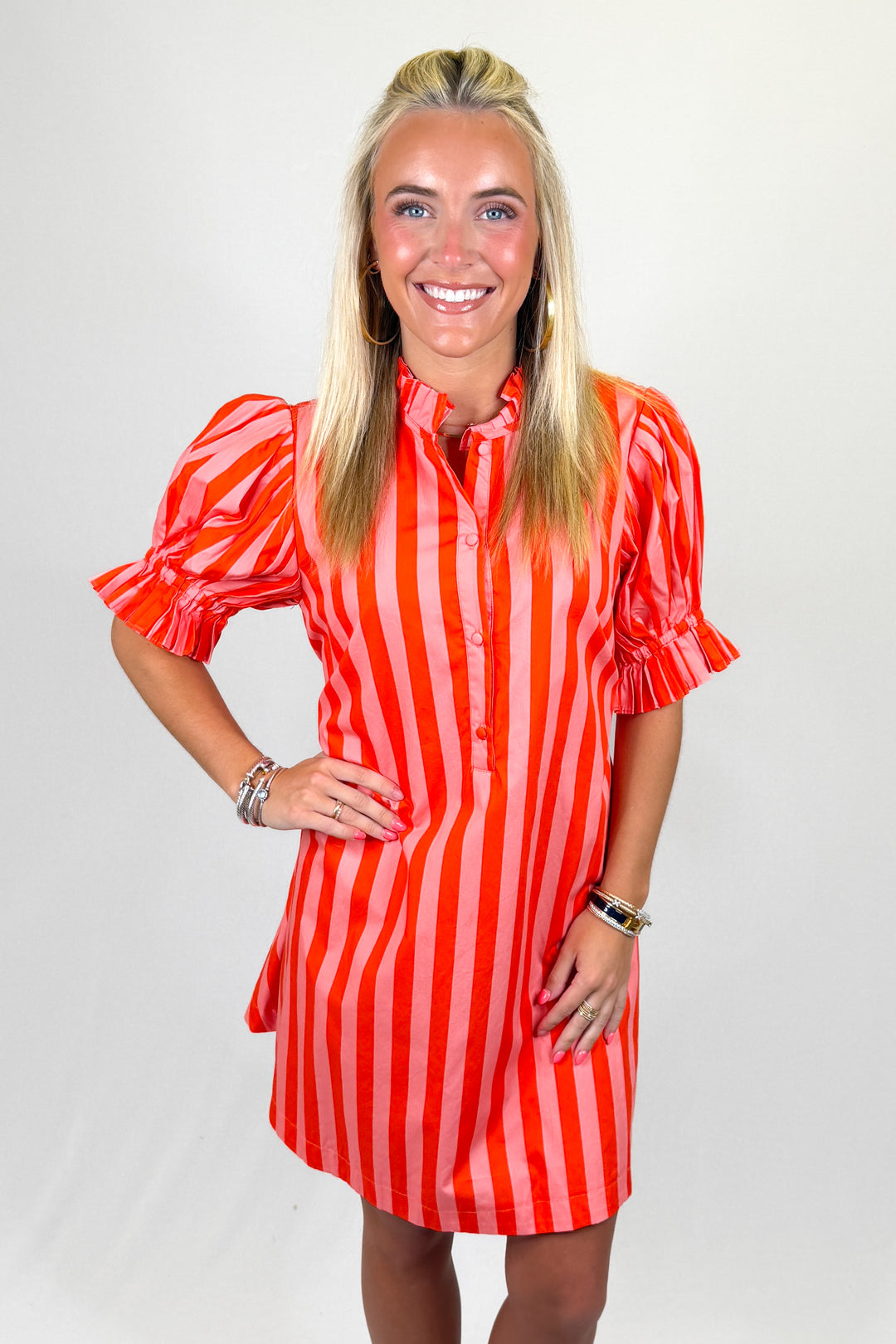 Woman wearing a red and white striped dress on a plain background