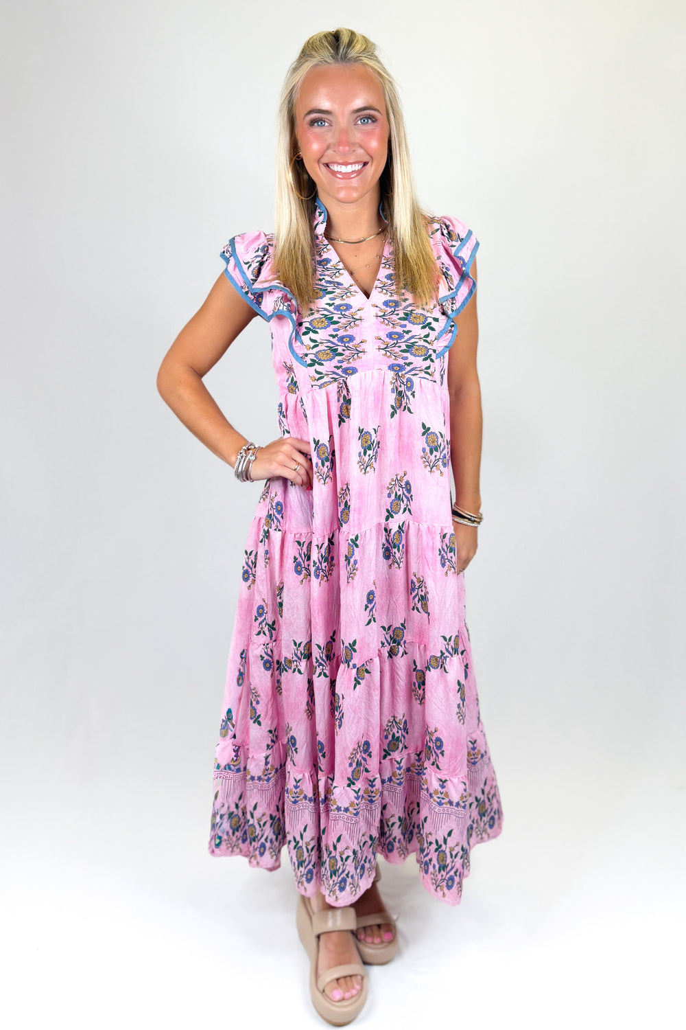 Woman wearing a pink floral dress on a white background