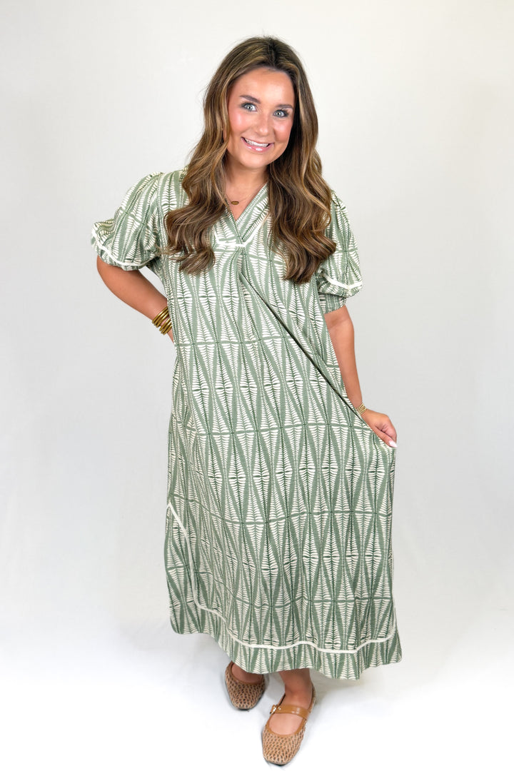 Woman wearing a green patterned dress on a white background
