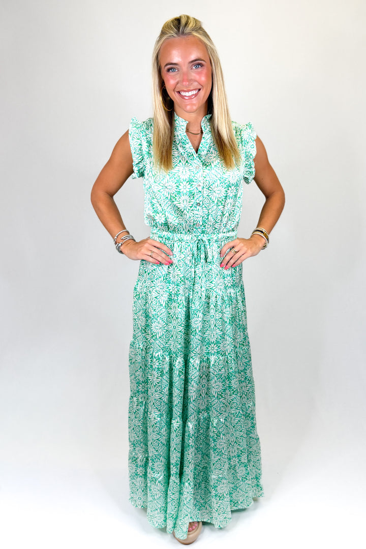 Woman wearing a green floral dress against a white background