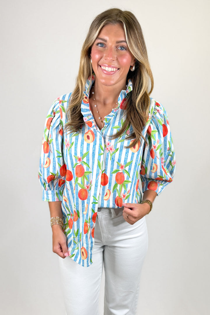 Woman wearing a colorful patterned shirt with a plain background