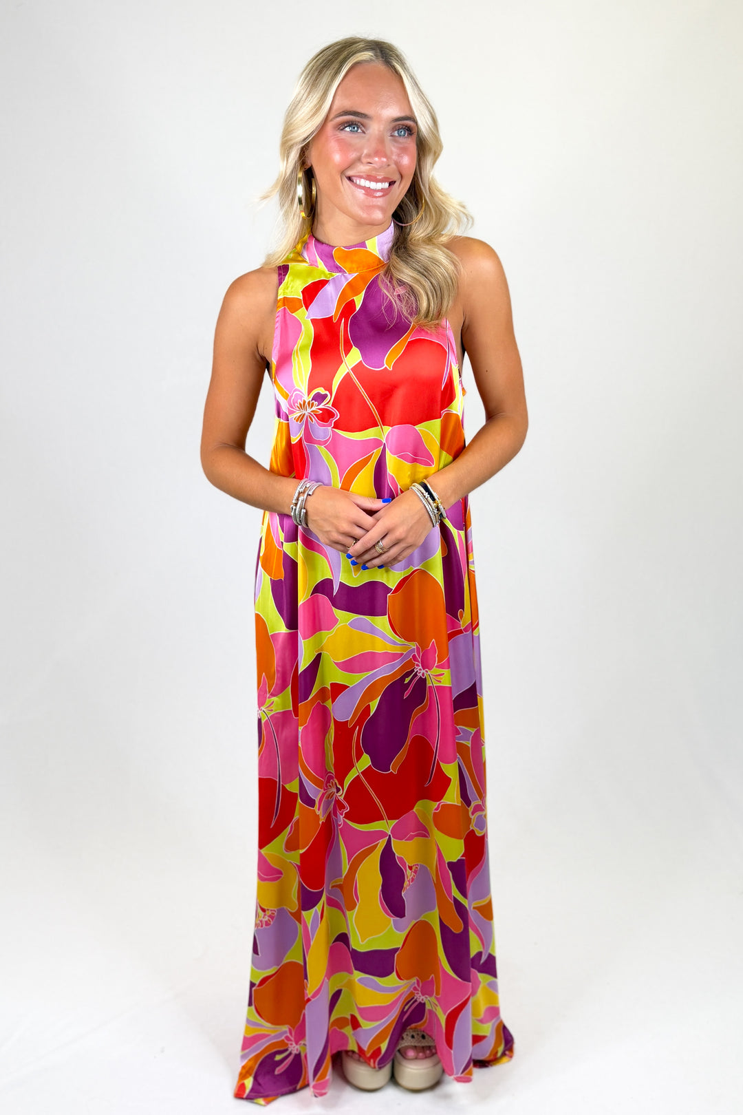 Woman wearing a colorful floral dress against a white background