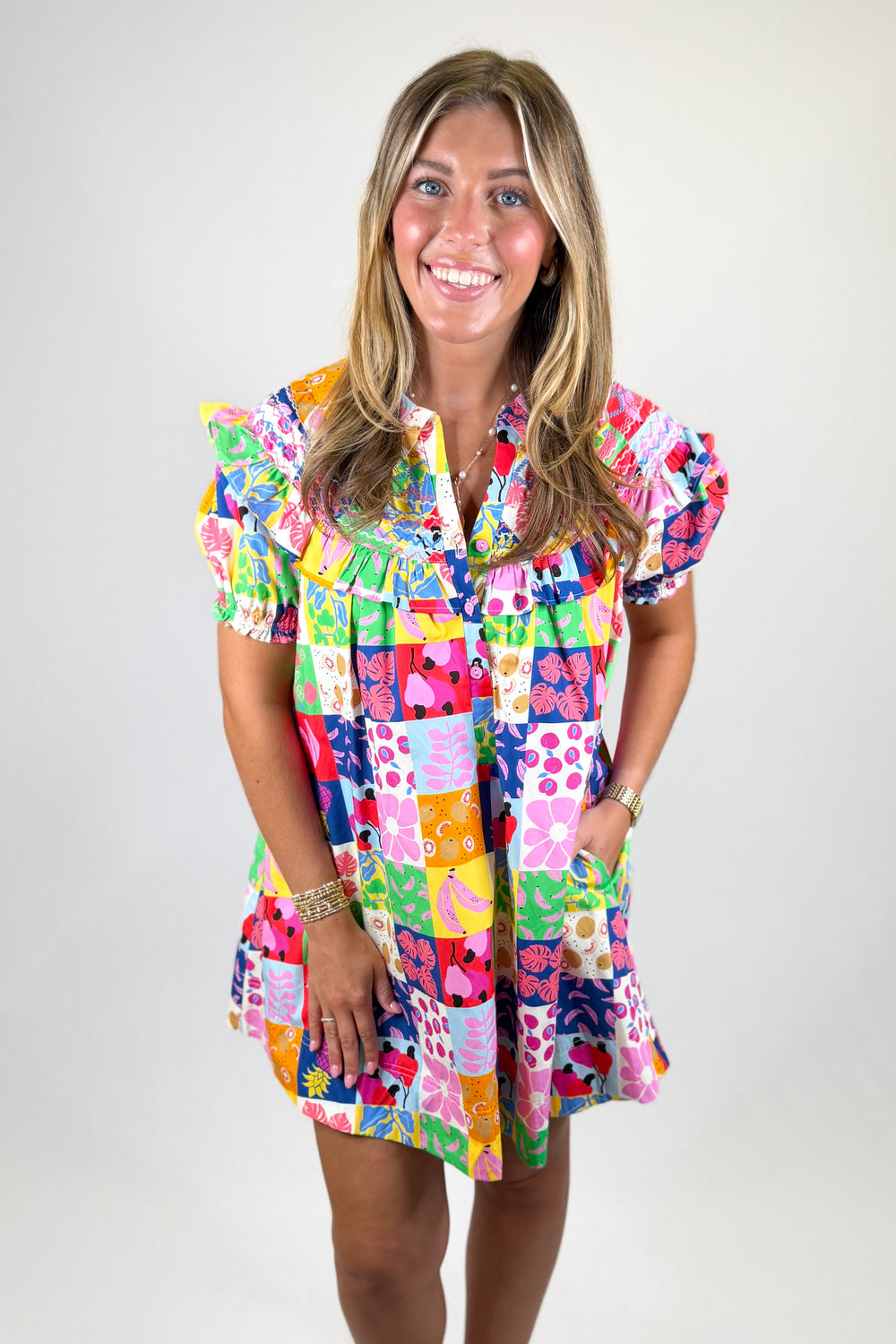 Woman wearing a colorful patterned dress on a plain background