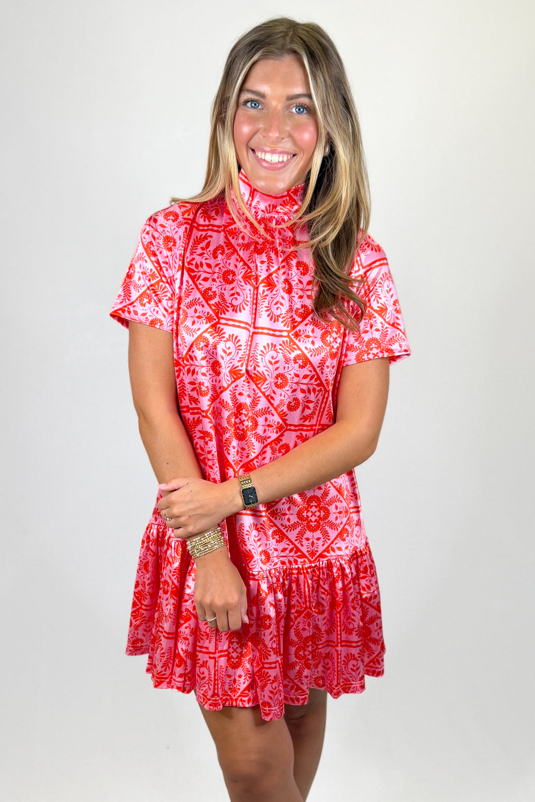 Woman wearing a red patterned dress against a white background