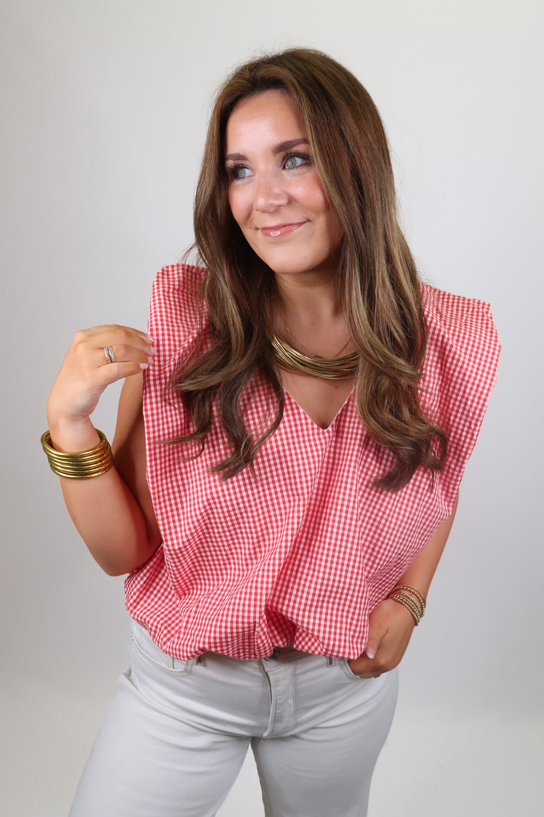 woman wearing a red gingham top on a solid background