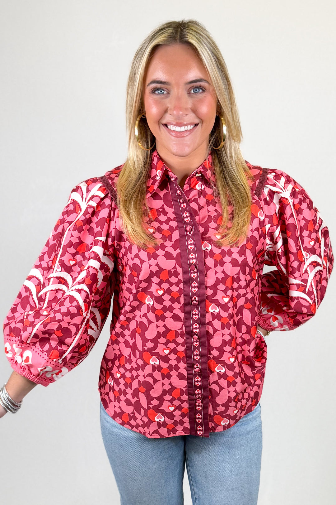 Woman wearing a red patterned blouse with a plain background