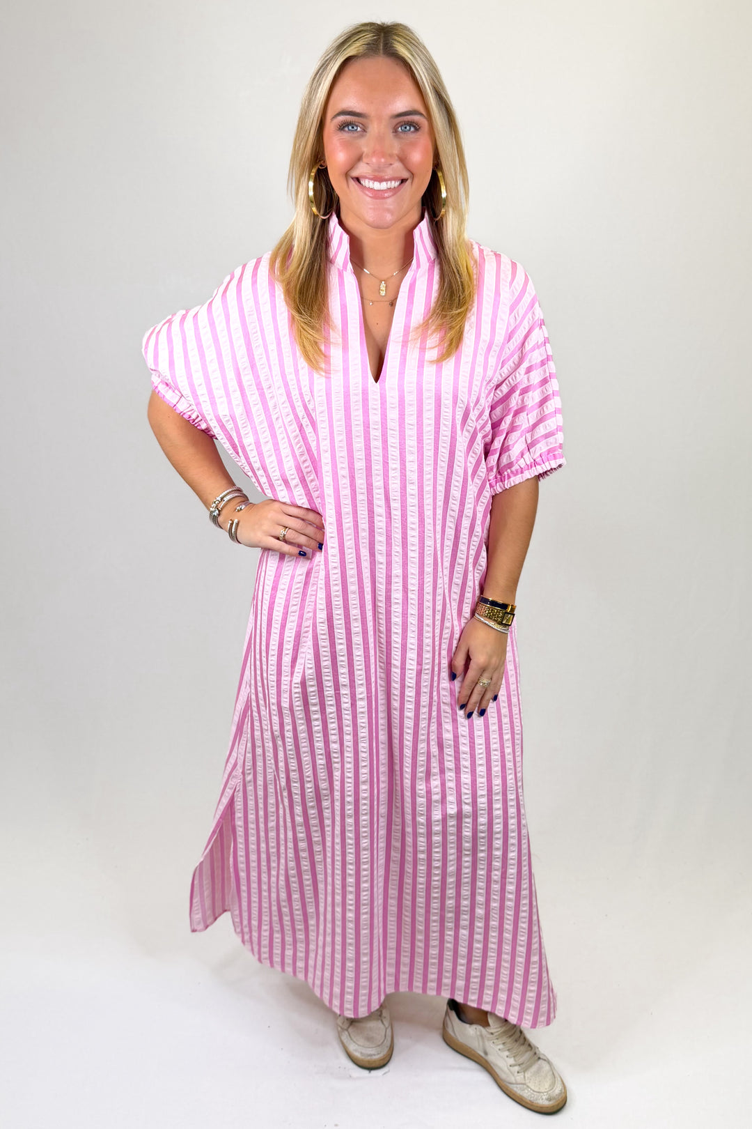 Woman wearing a pink and white striped dress on a plain background