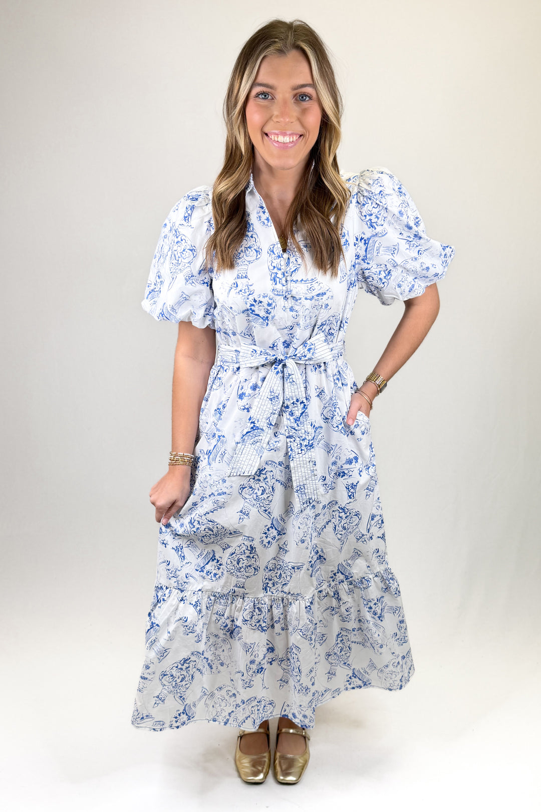 Woman wearing a blue floral dress against a plain background